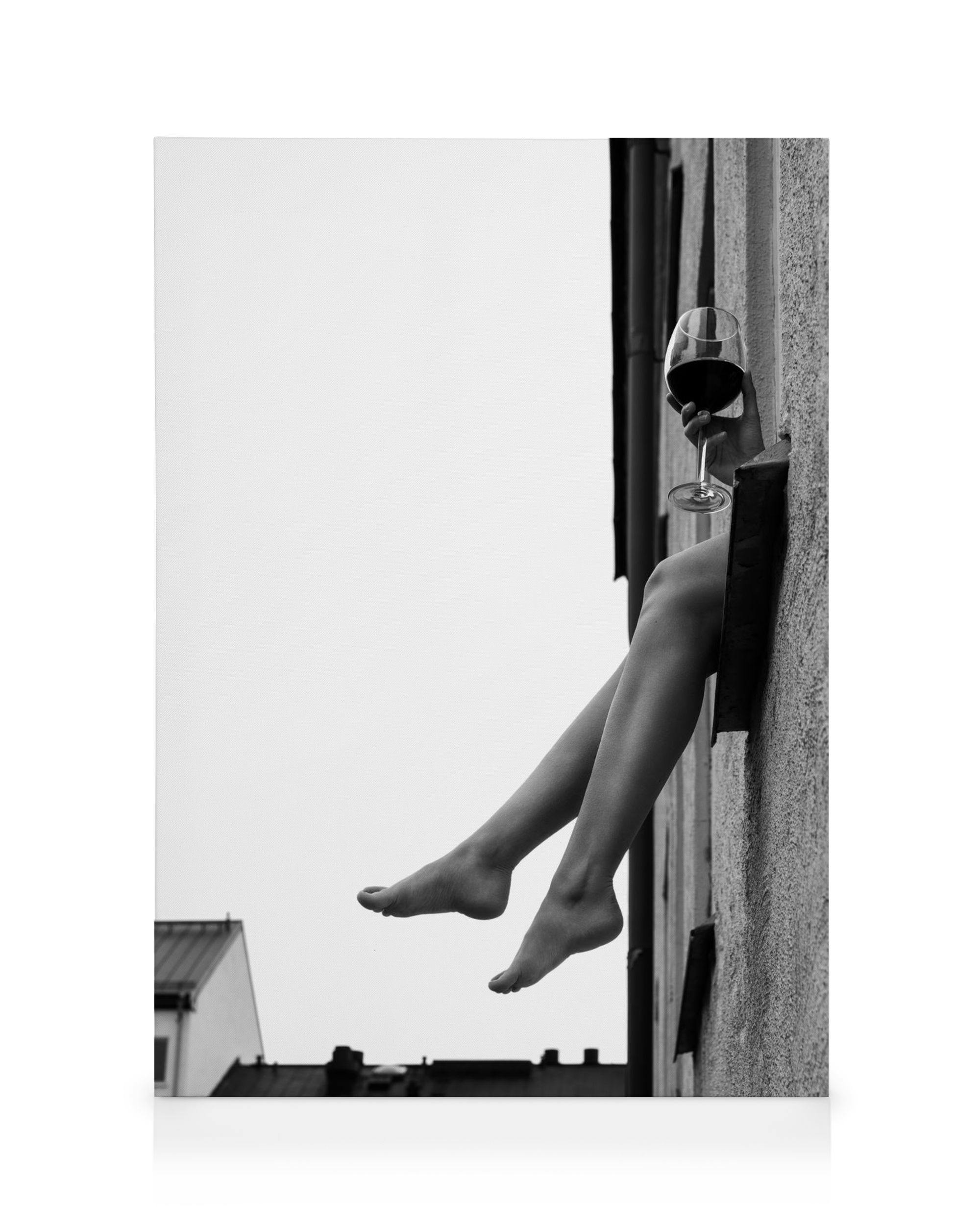 Black and white fashion photo canvas print of bare legs dangling from a window with a glass of red wine.