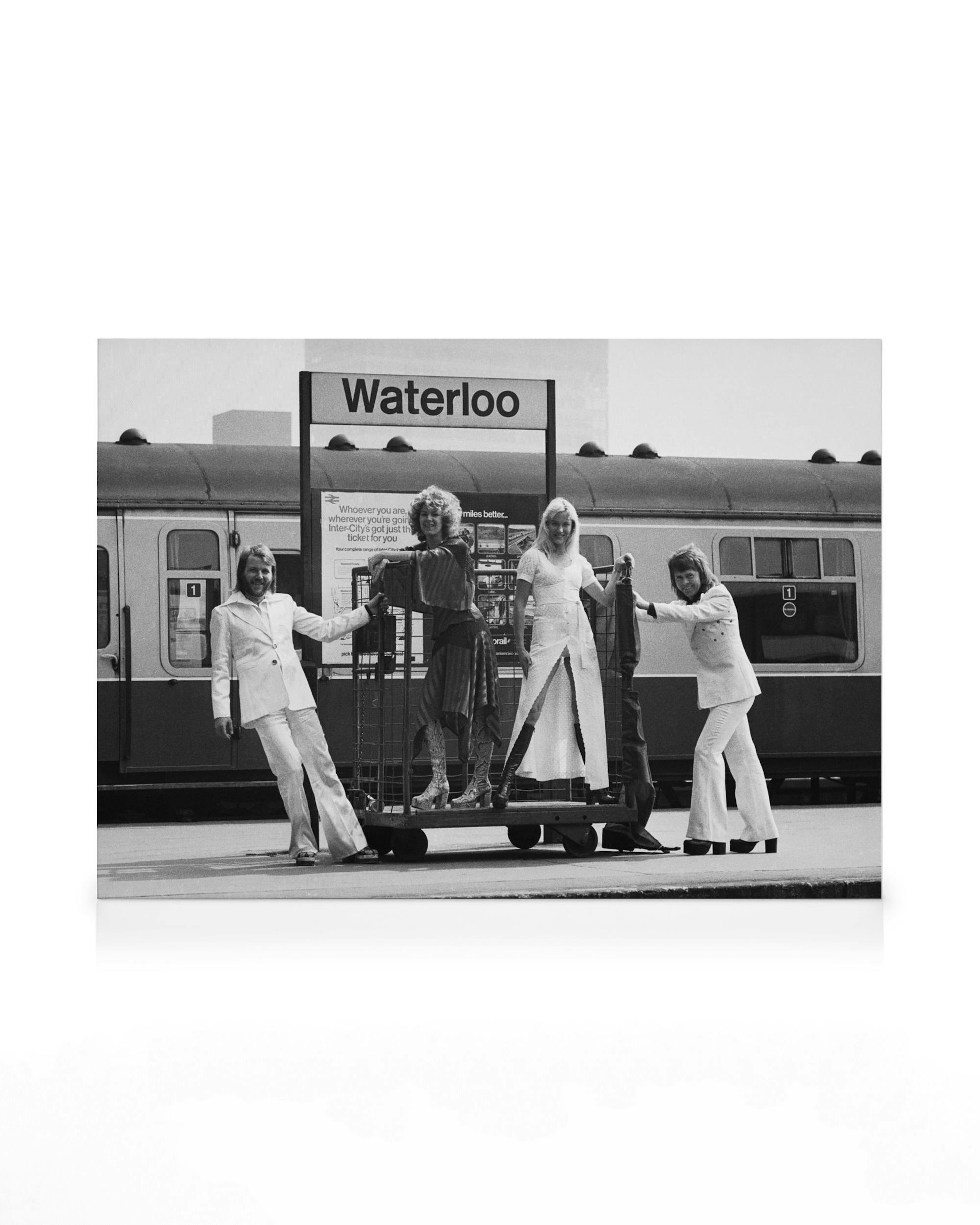 Black and white ABBA canvas print: 70s band posing with luggage at Waterloo station, London.