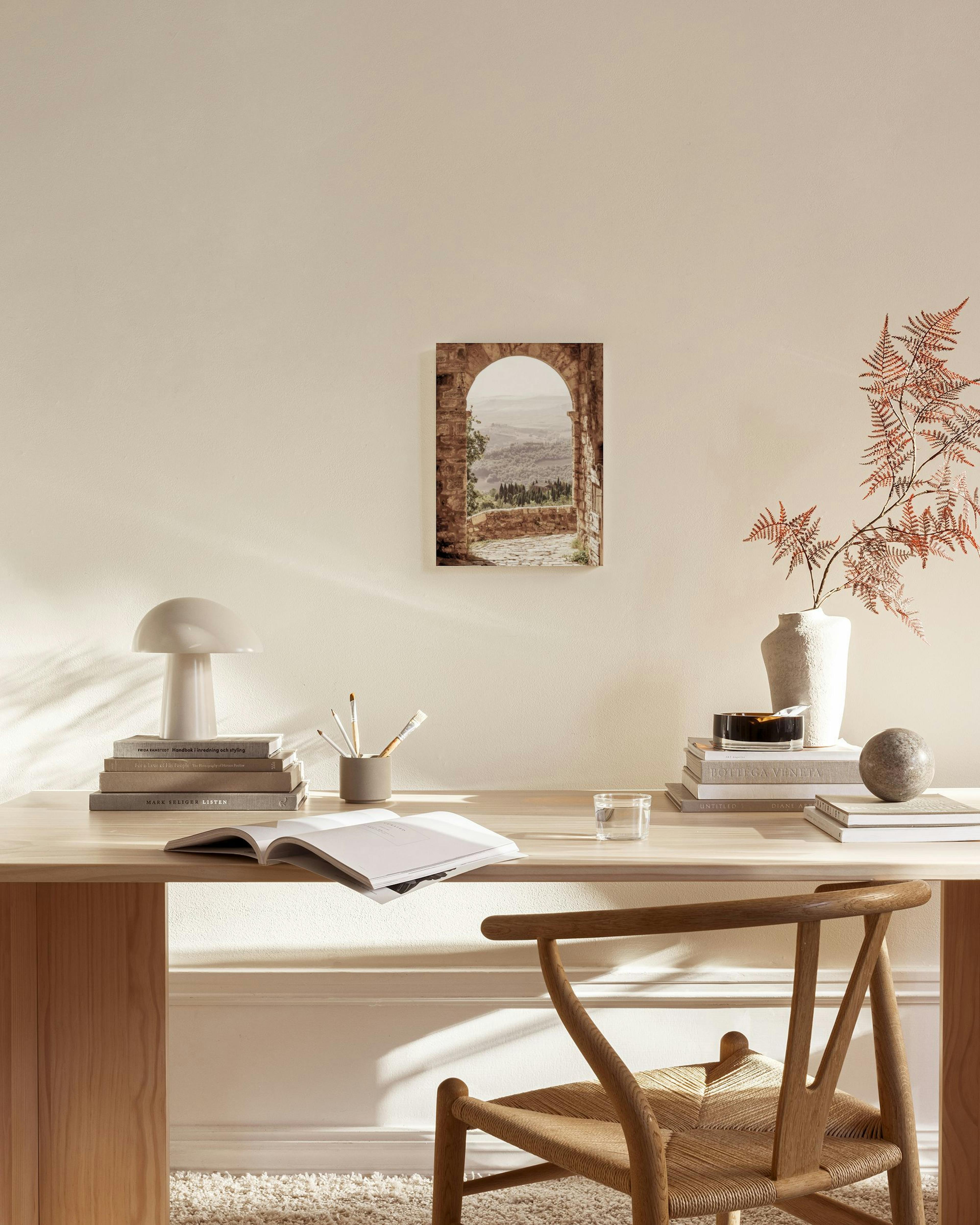 Toile murale d’une arche de pierre rustique donnant sur un paysage vallonné, affichée dans un salon moderne aux tons neutres.