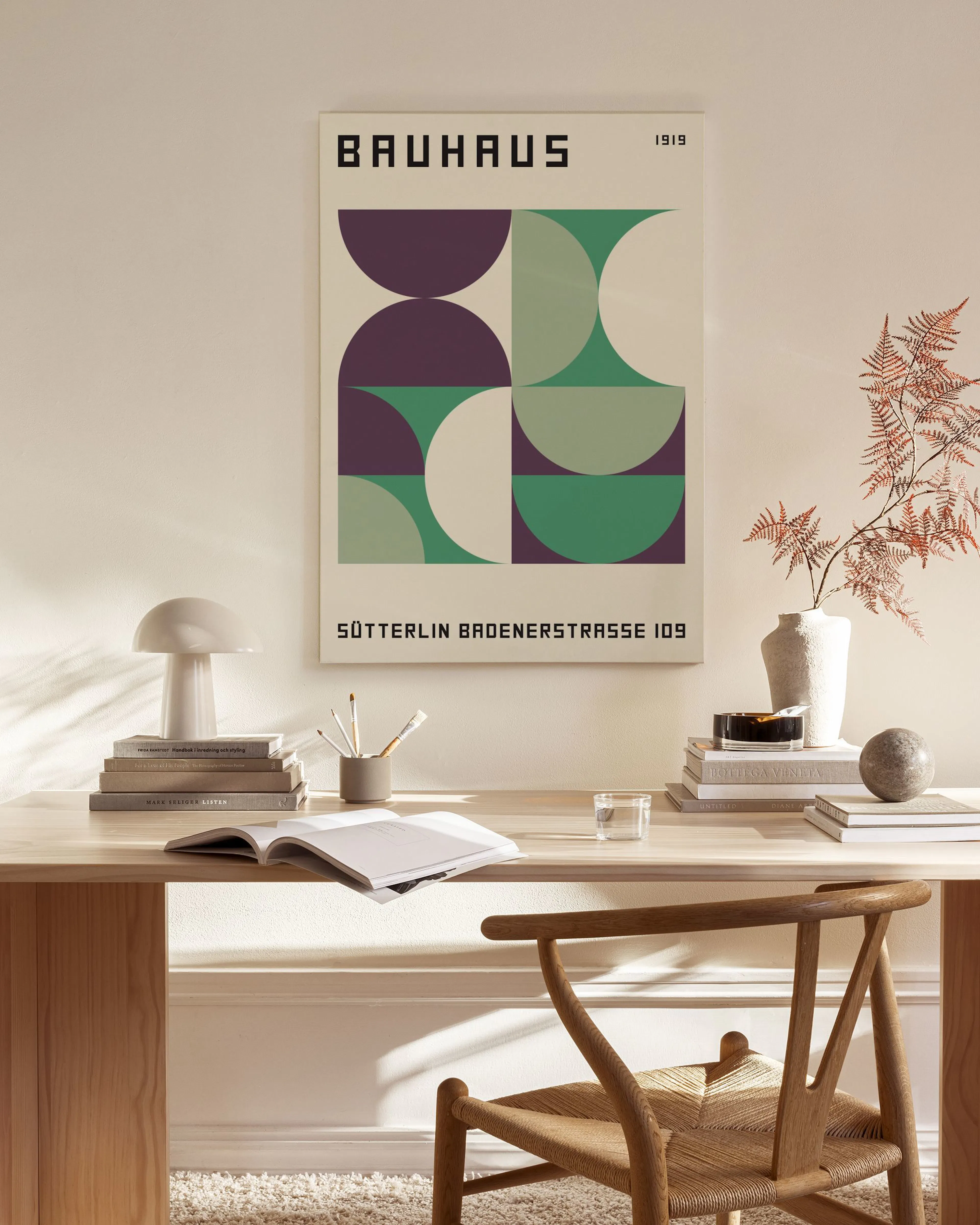 A Bauhaus style canvas print with geometric shapes in purple, green, and white, displayed in a bright living room.