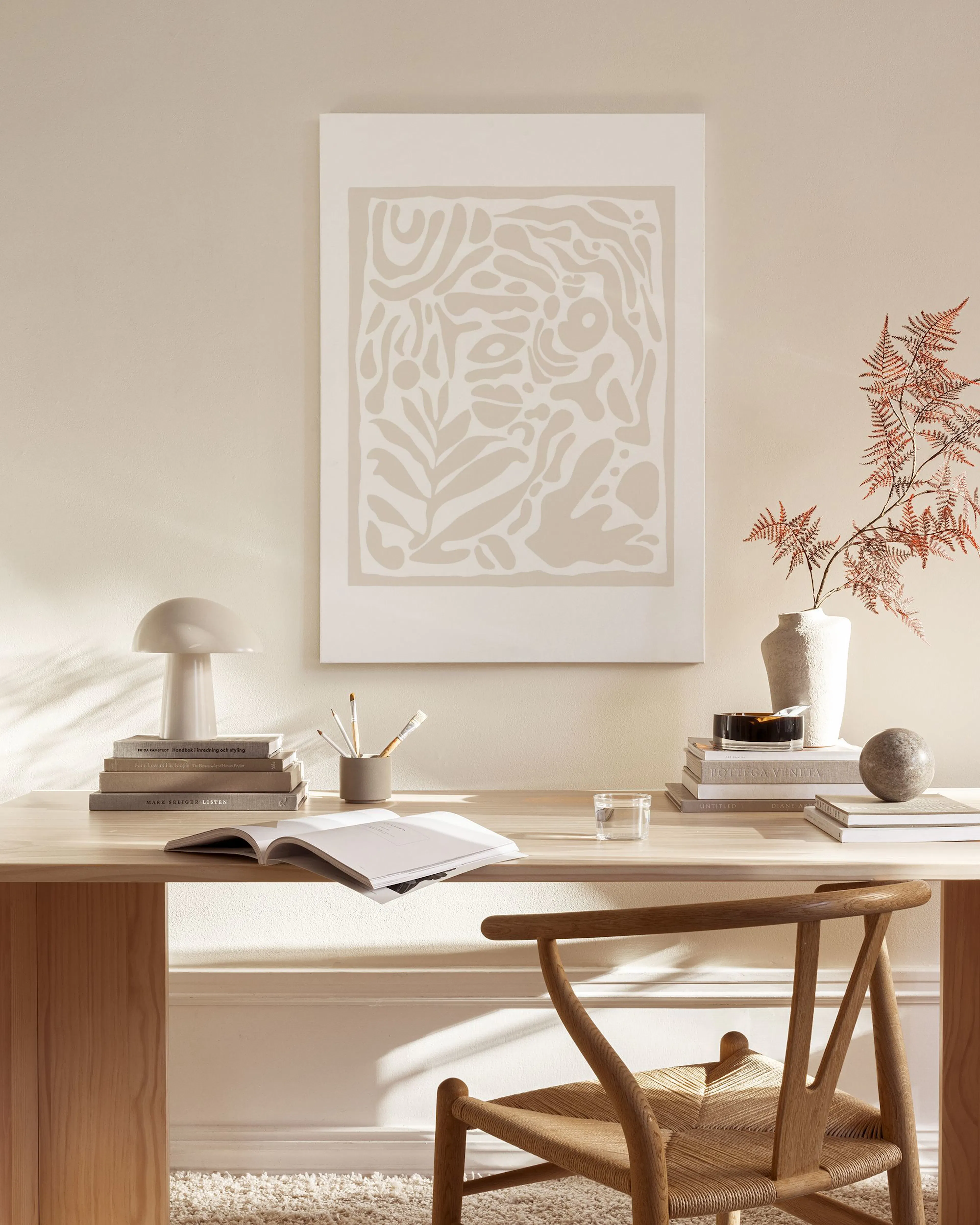 Leinwandbild mit organischen Formen in Beige- und Cremetönen, aufgehängt in einem hellen, minimalistischen Wohnzimmer.
