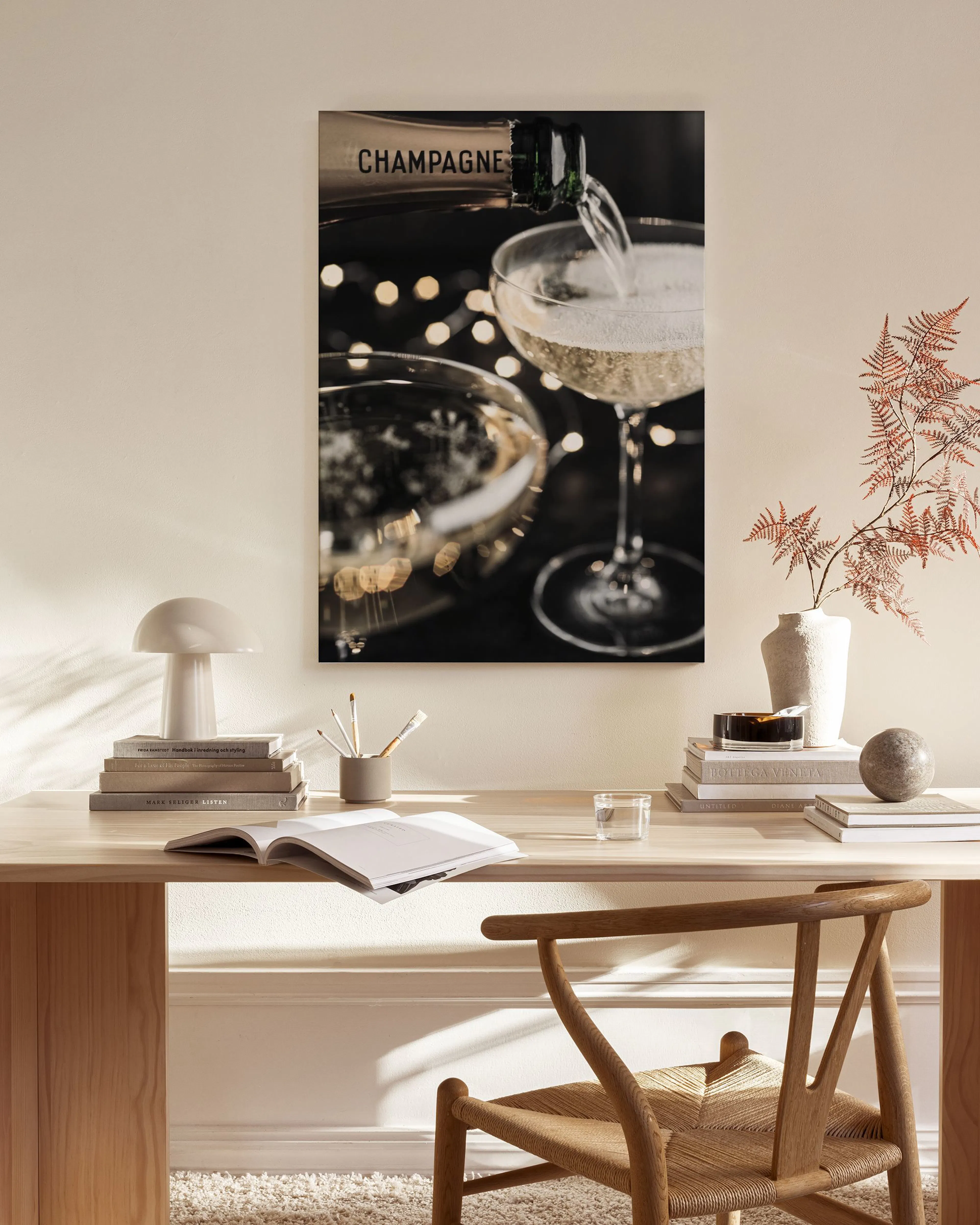 Toile de champagne versé dans un verre, affichée dans un salon moderne avec fauteuil et lampe.