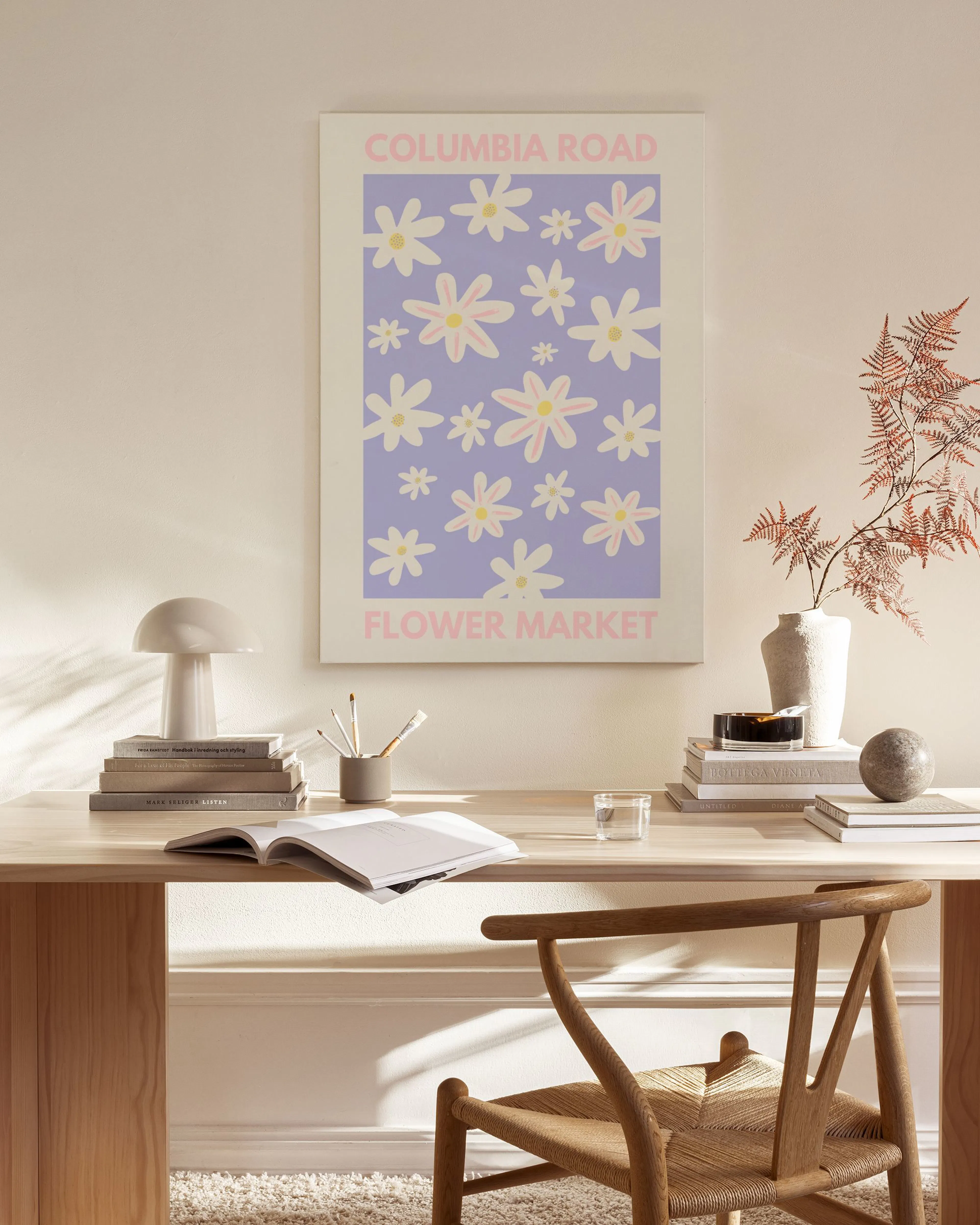Flower market canvas print with white and yellow daisies on a lilac background, hanging above a wooden console table.