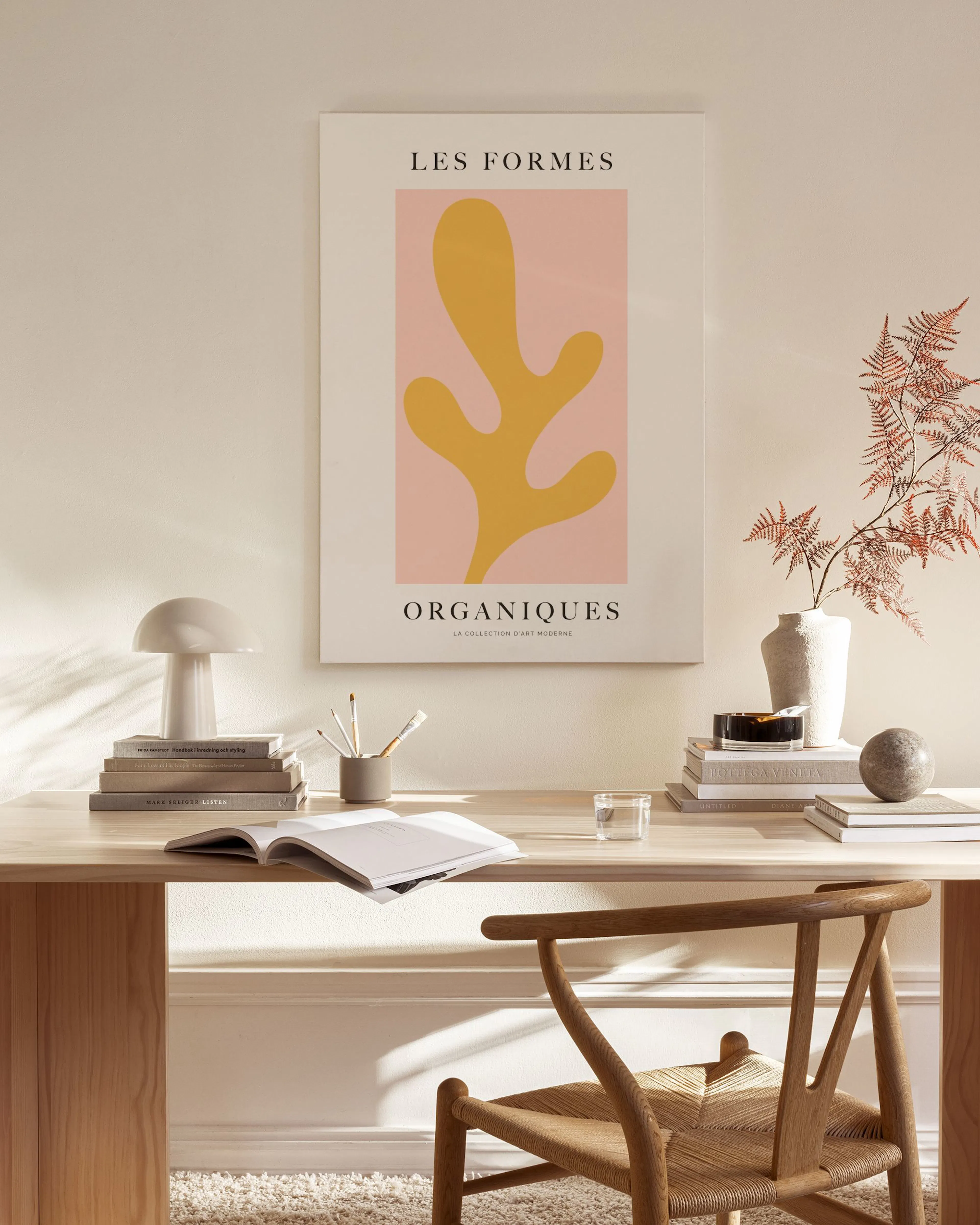 Toile Les Formes Organiques aux formes abstraites jaune ocre sur fond rose, accrochée dans un salon moderne au-dessus dun meuble