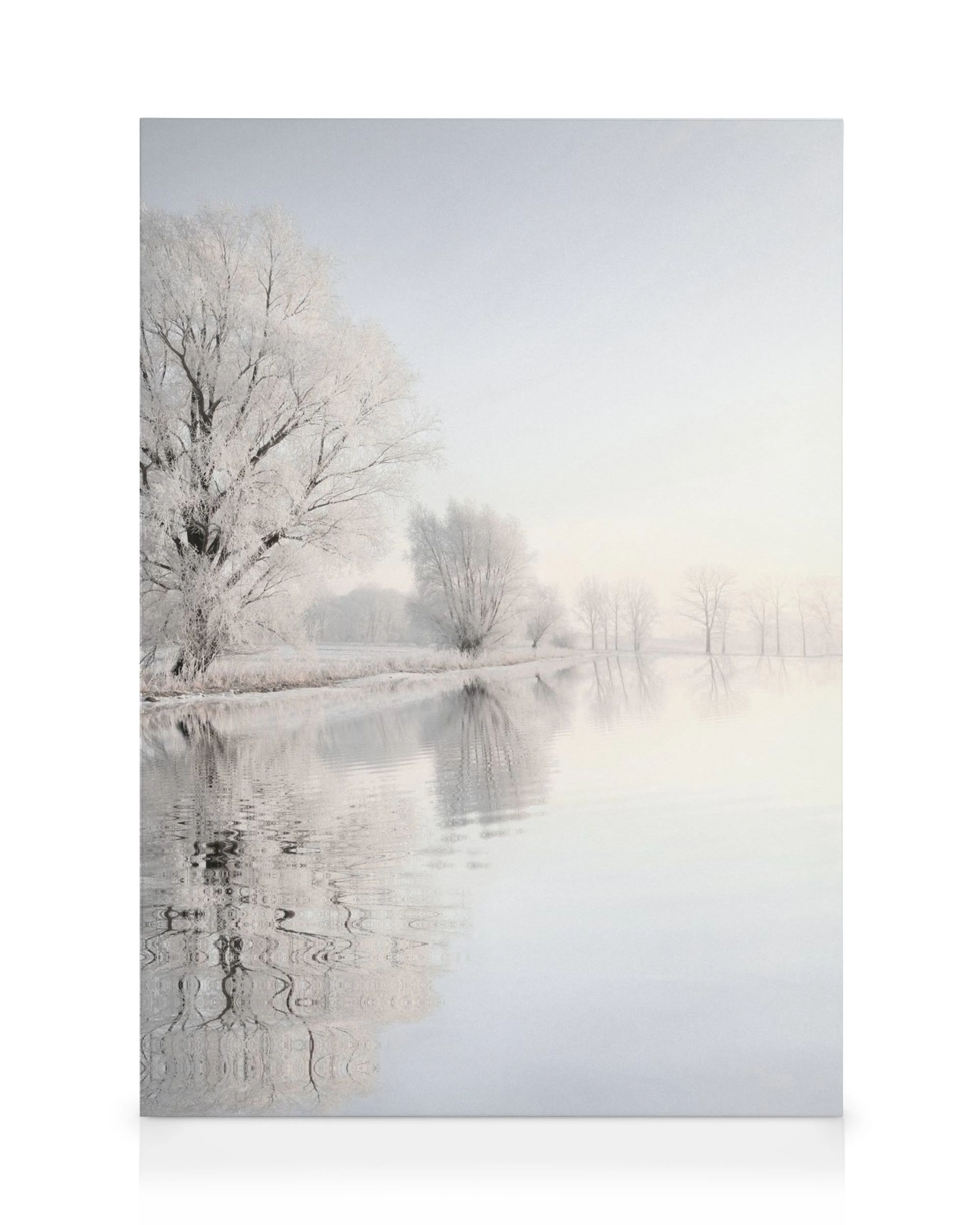 Winterliche Landschaft mit Bäumen, die von Raureif bedeckt sind, und einem ruhigen See, der die Szenerie spiegelt.