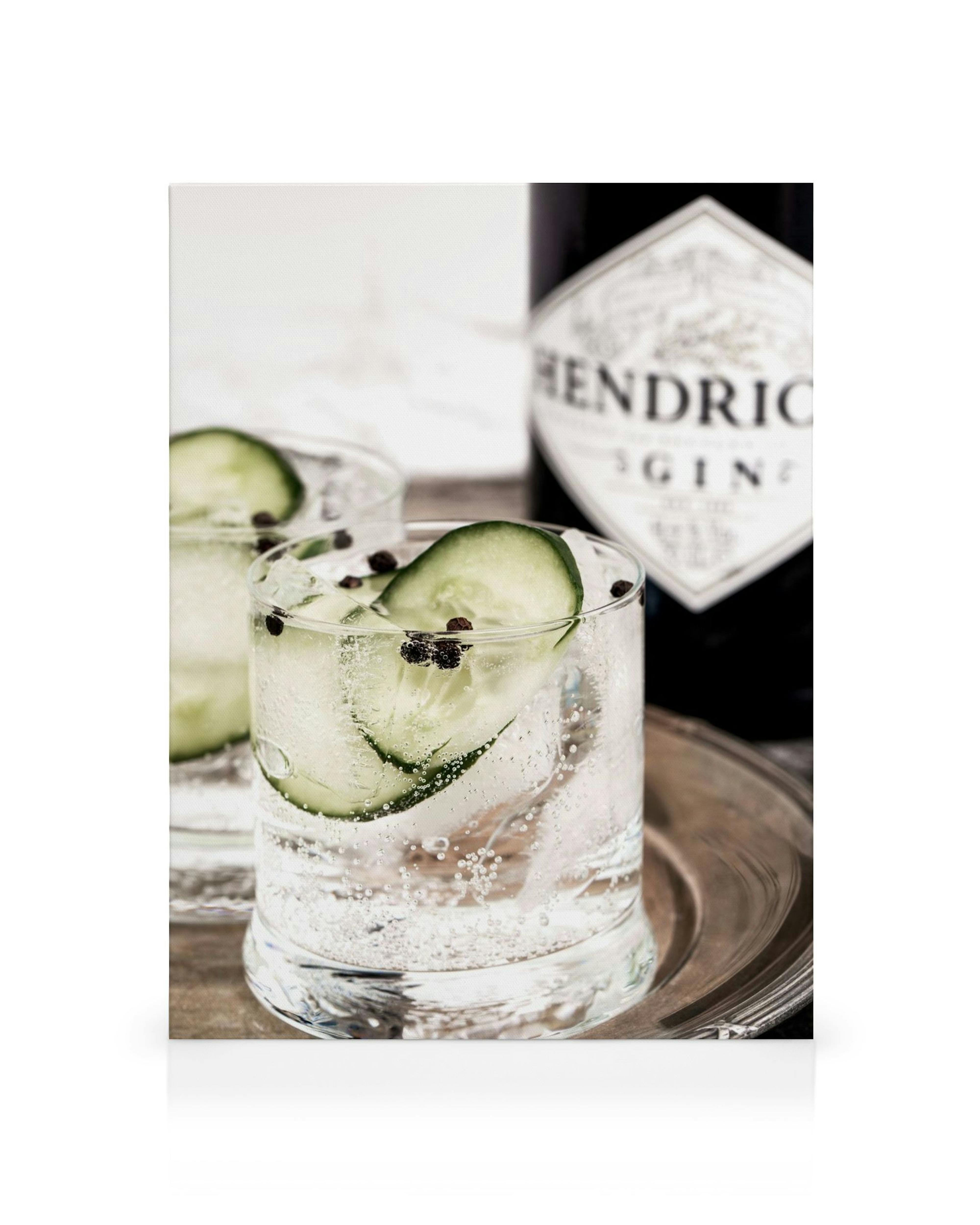 Gin Tonic Gläser mit Gurkenscheiben und Gin-Flasche auf einem Tablett