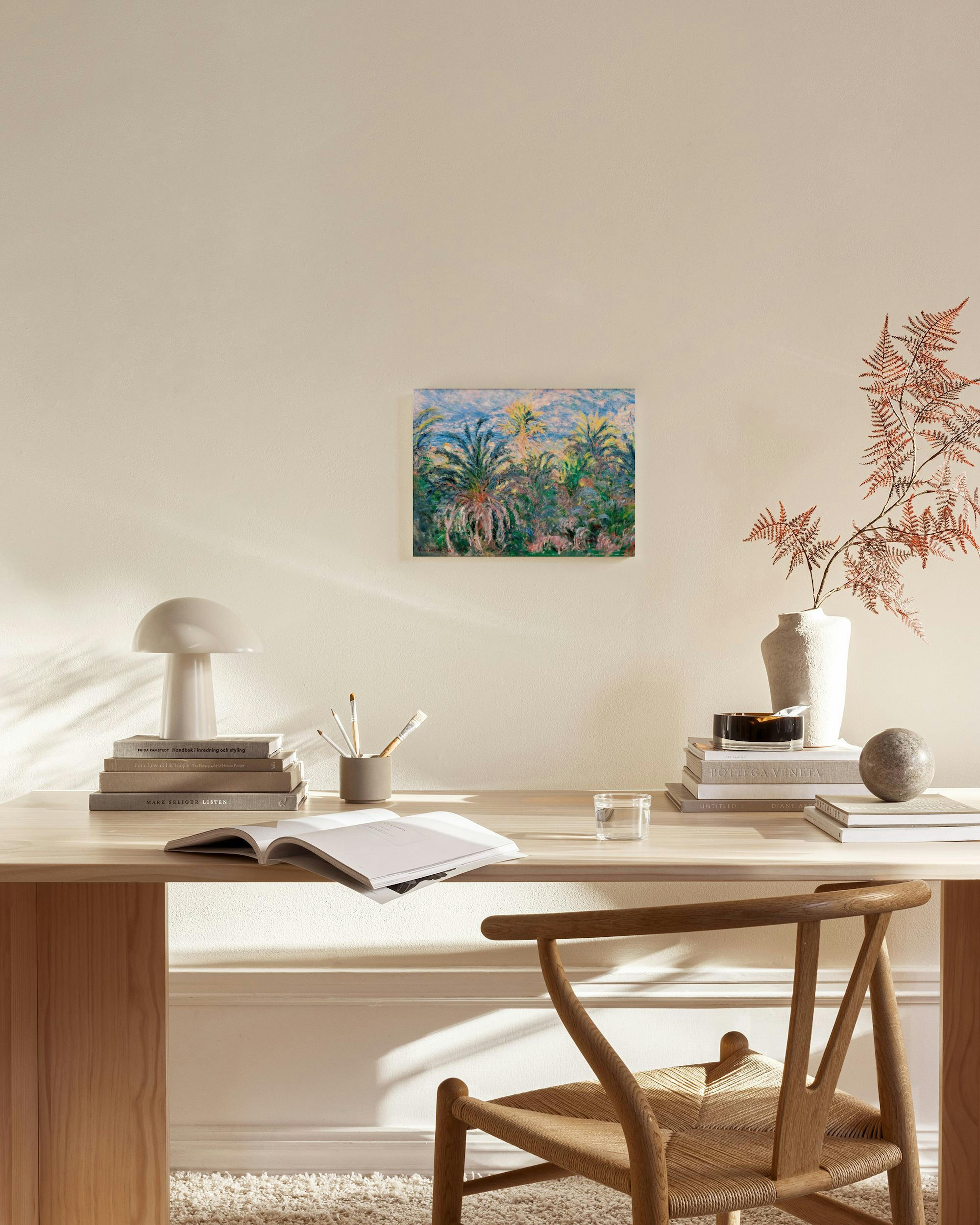 Canvastavla med exotiska palmer i grönt och rosa, hängande ovanför en bänk i ett ljust vardagsrum.