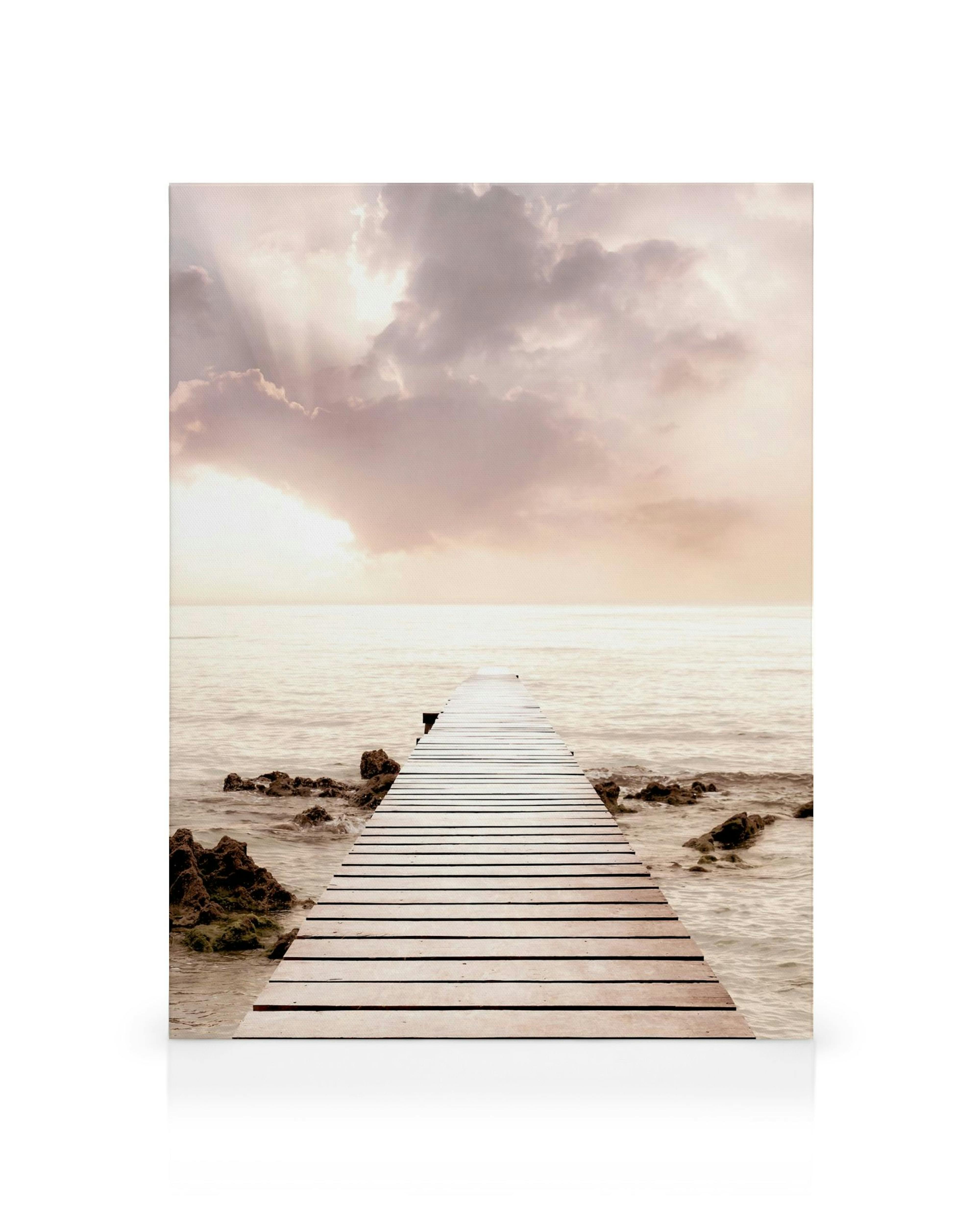 Wooden jetty extending into the sea at sunset with pink, white, and blue clouds. Serene canvas print.