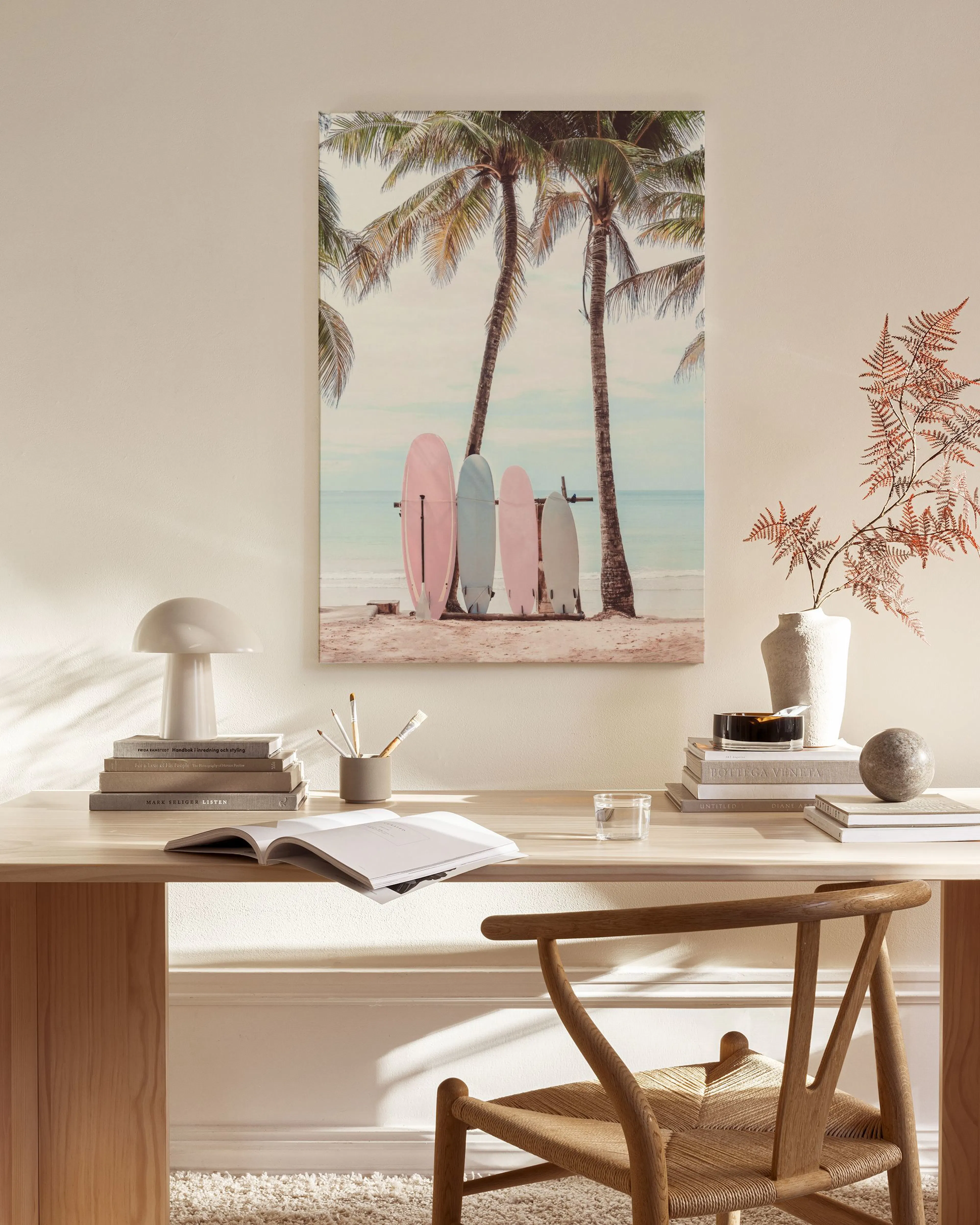 Toile murale de planches de surf pastel sur une plage tropicale, accrochée au-dessus dun banc en bois dans un salon moderne.