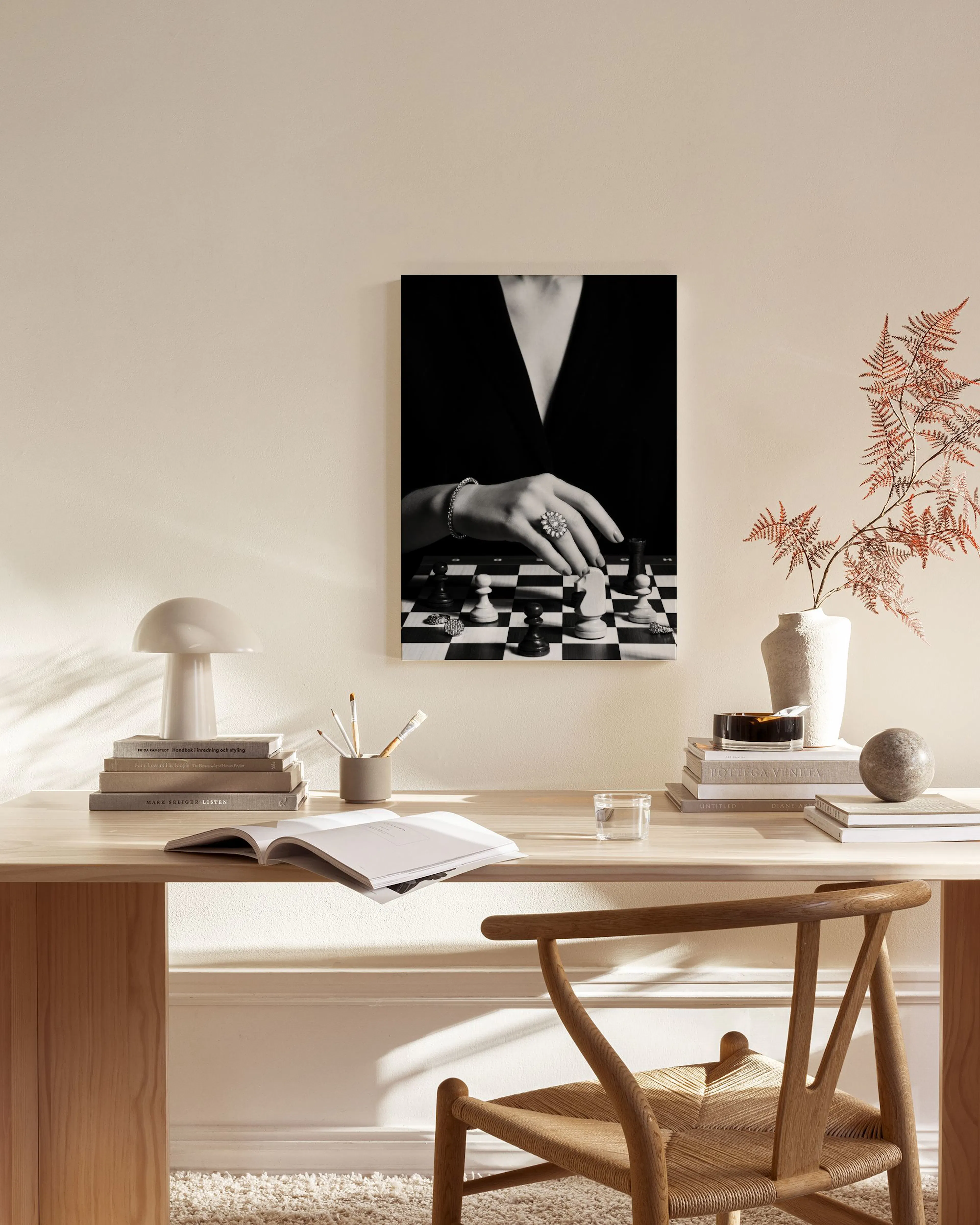 Schwarz-weißes Leinwandbild einer Hand beim Schachspiel, platziert in einem modern eingerichteten Wohnzimmer.