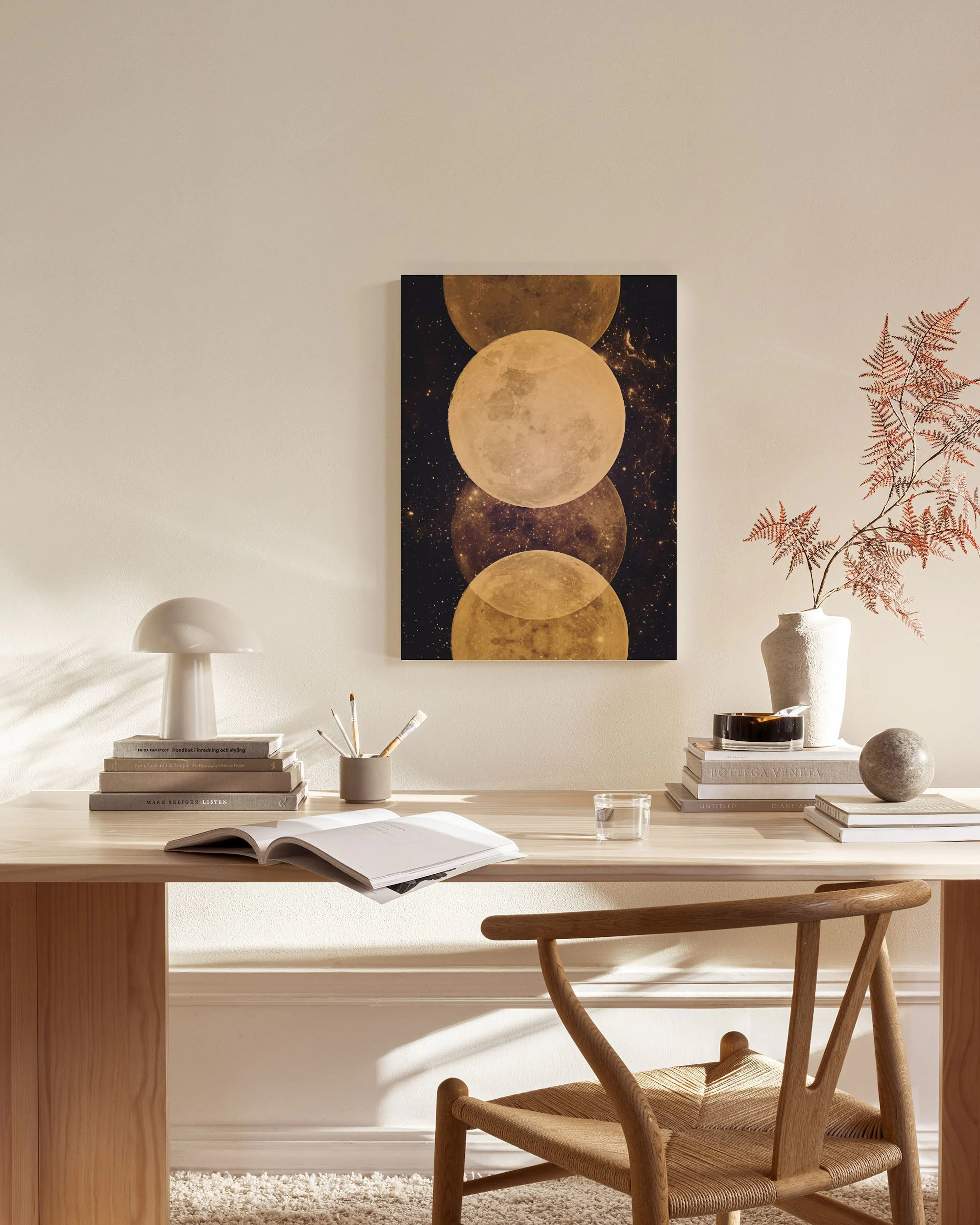Leinwandbild mit mehreren goldgelben Monden vor Sternenhimmel, hängend über einem Sideboard im Wohnzimmer.