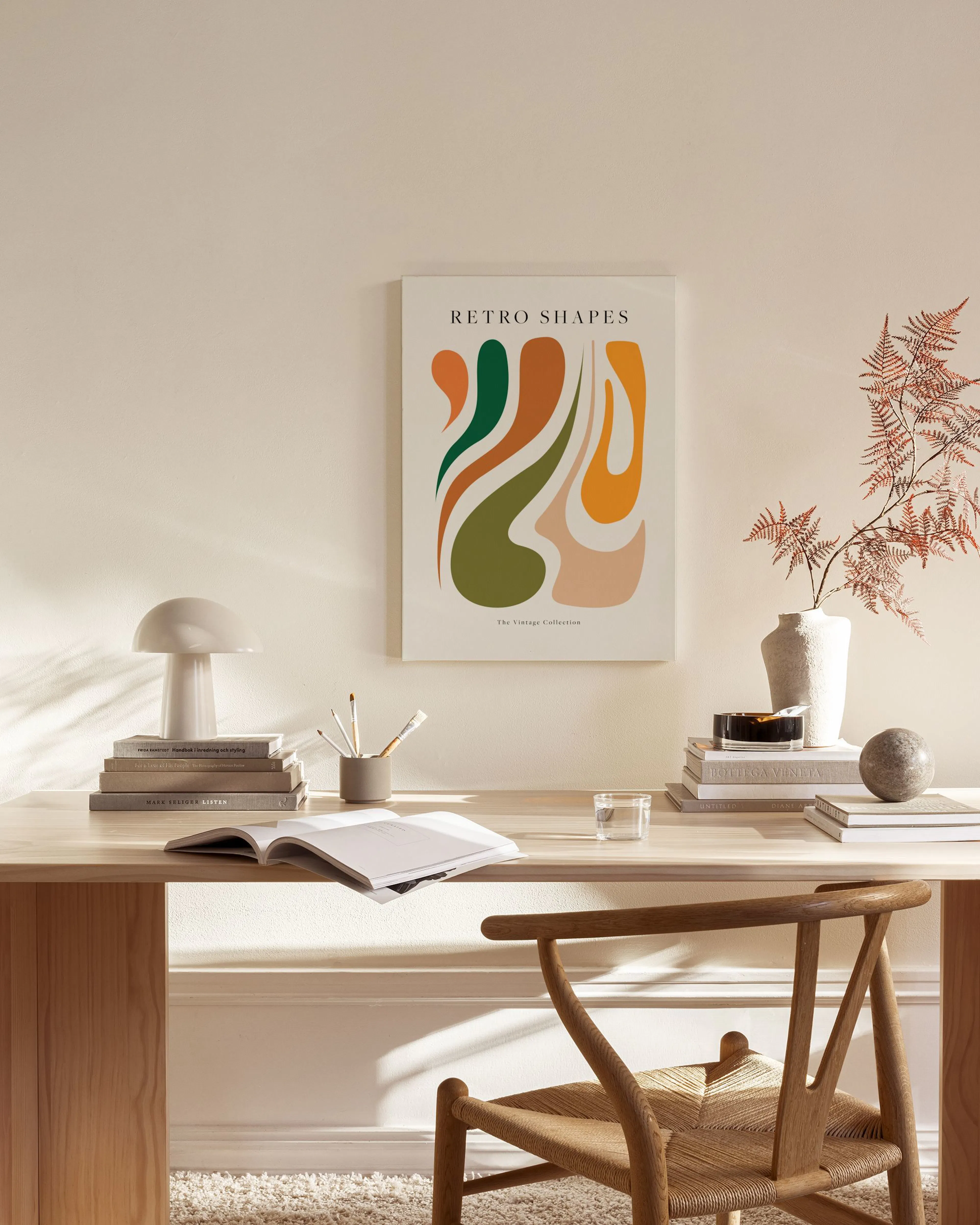 Leinwandbild mit Retro-Formen in Grün, Orange und Beige, hängend über einem Lowboard in einem hellen Wohnzimmer.
