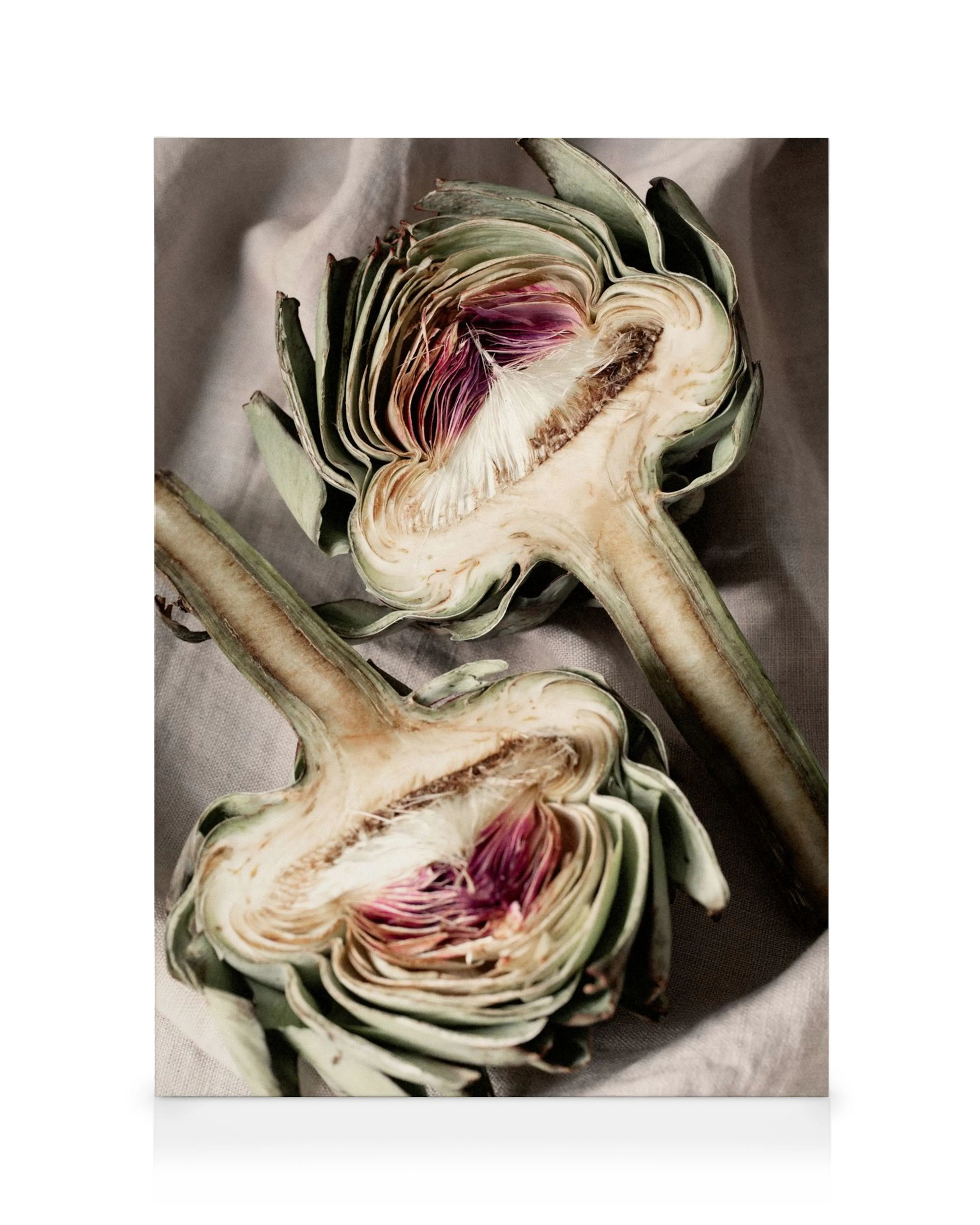 Halved artichokes in purple, white, and green on a gray surface, a vibrant canvas print.