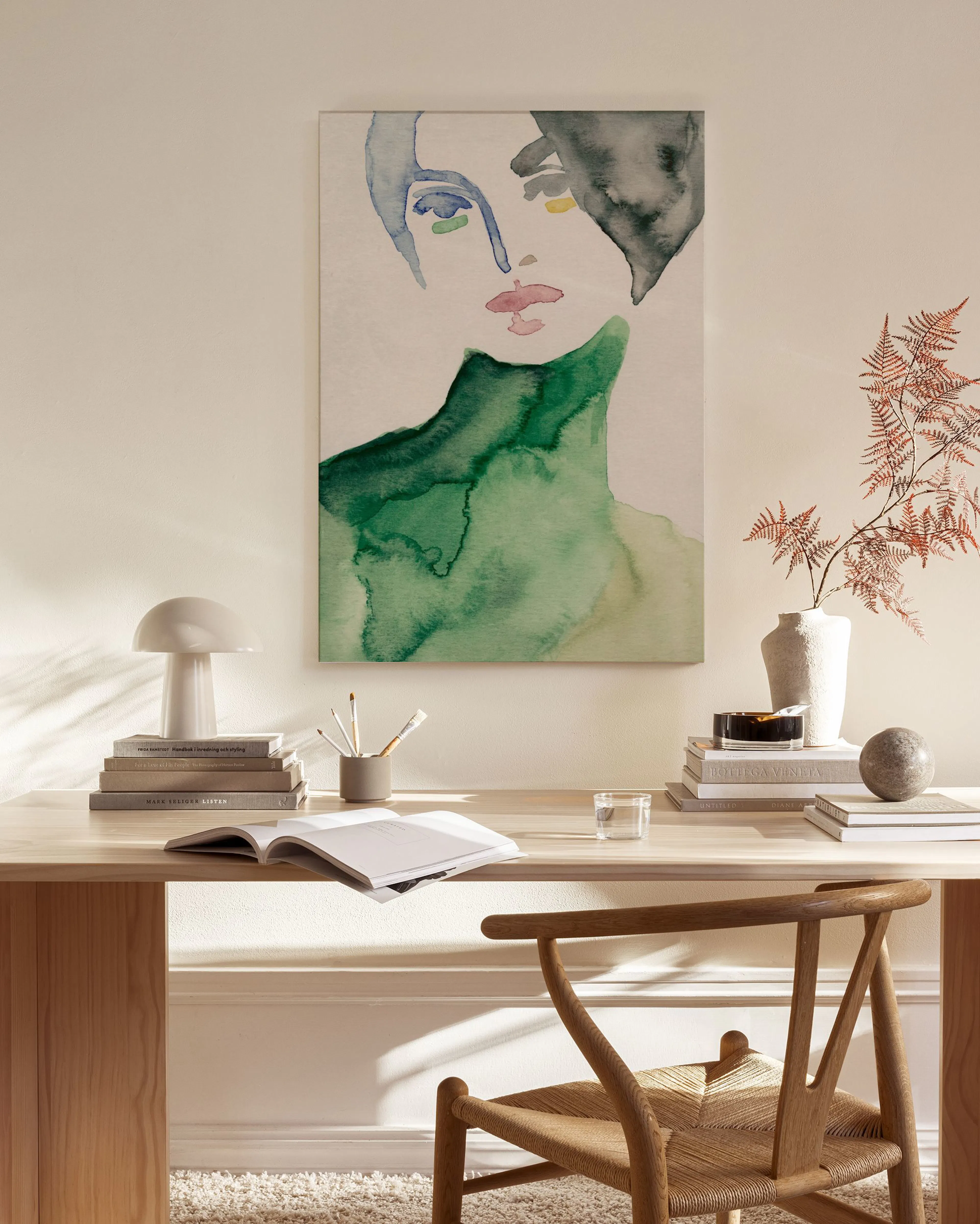 Watercolor abstract portrait of a woman with green and gray, hanging in a minimalist living room.