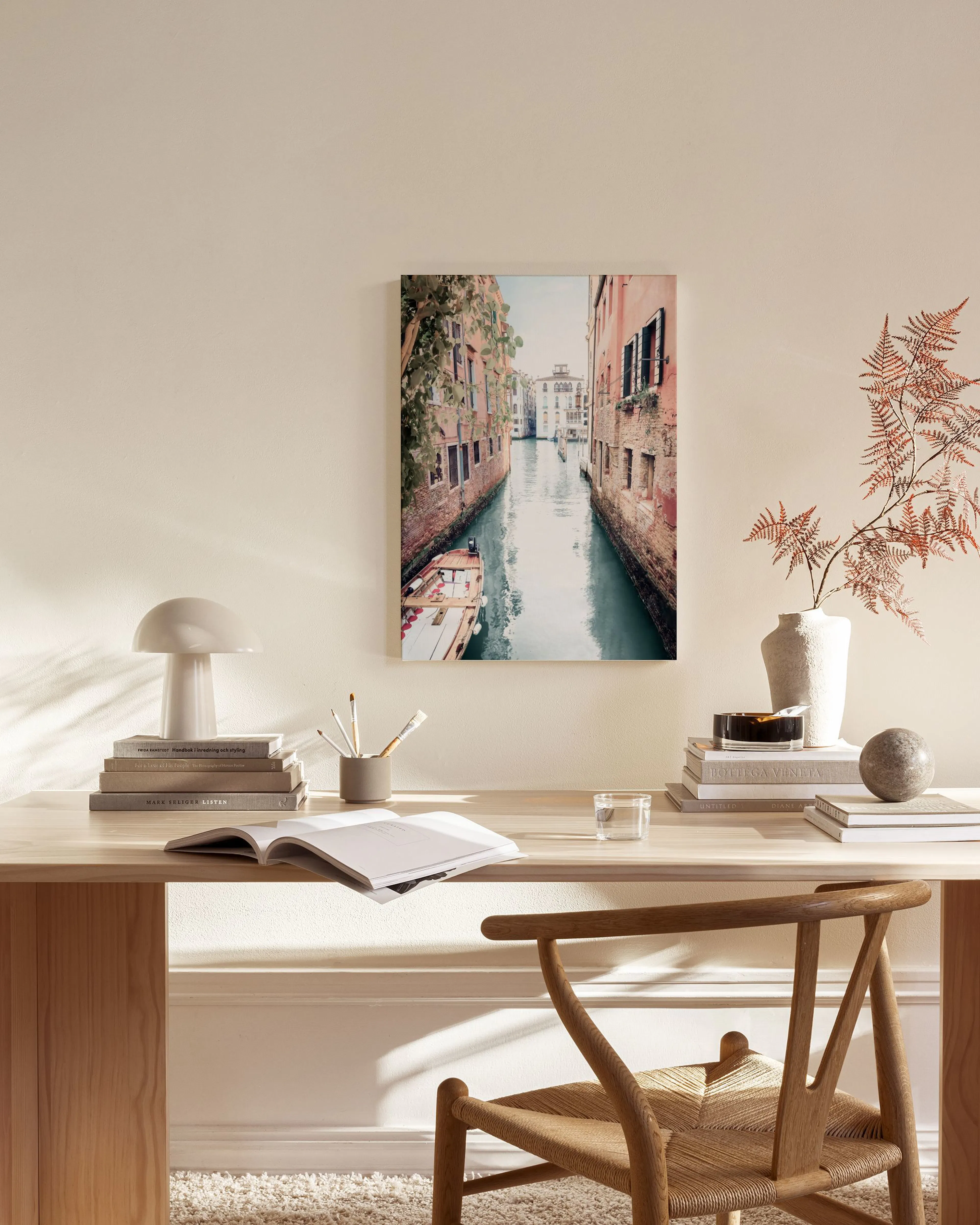 Leinwandbild eines venezianischen Kanals in einem modernen Wohnzimmer über einem Sideboard mit Lampe und Vase.