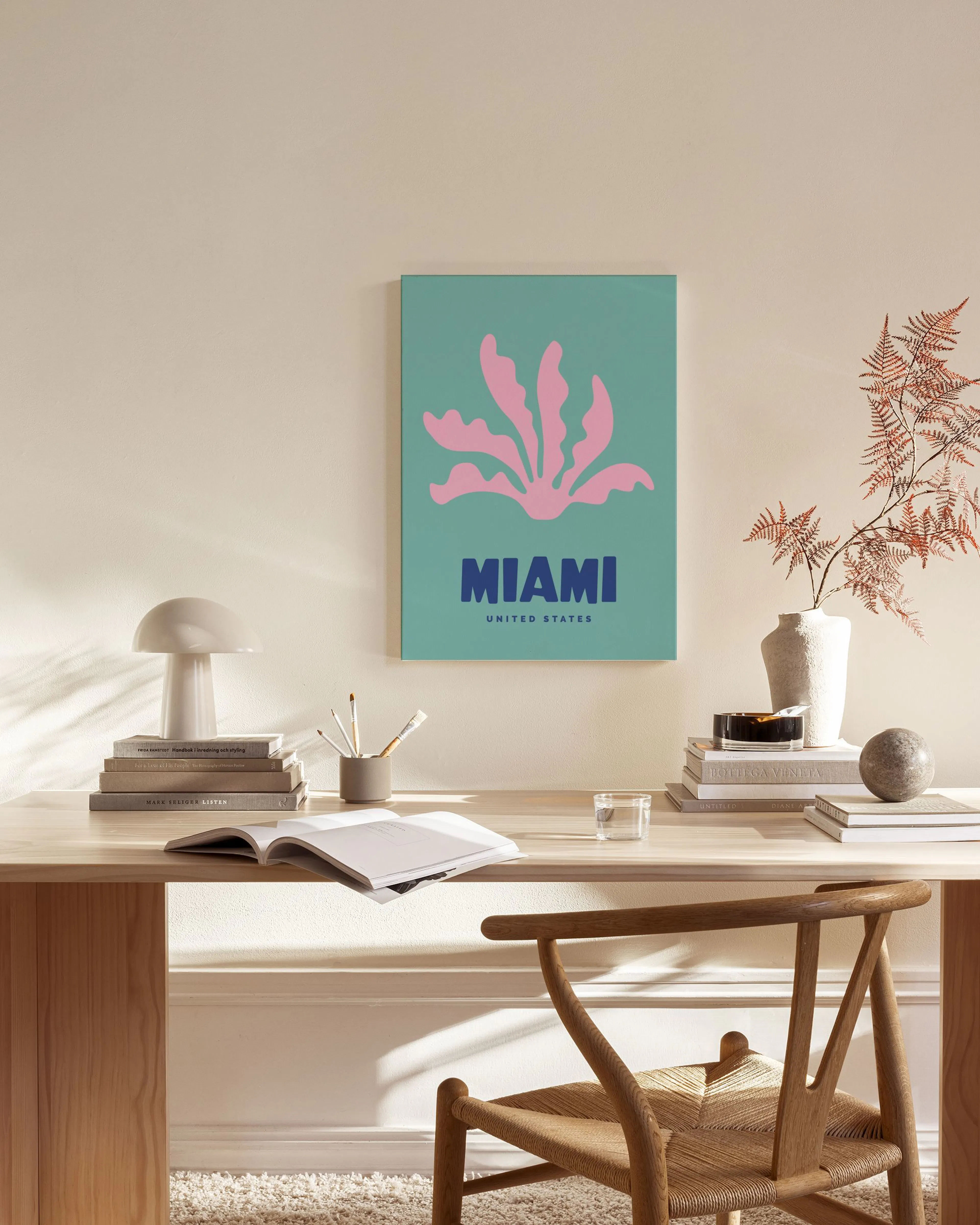 Obraz na plátně Miami s růžovou rostlinou na tyrkysovém pozadí, visící v moderním obývacím pokoji nad nízkou skříňkou.