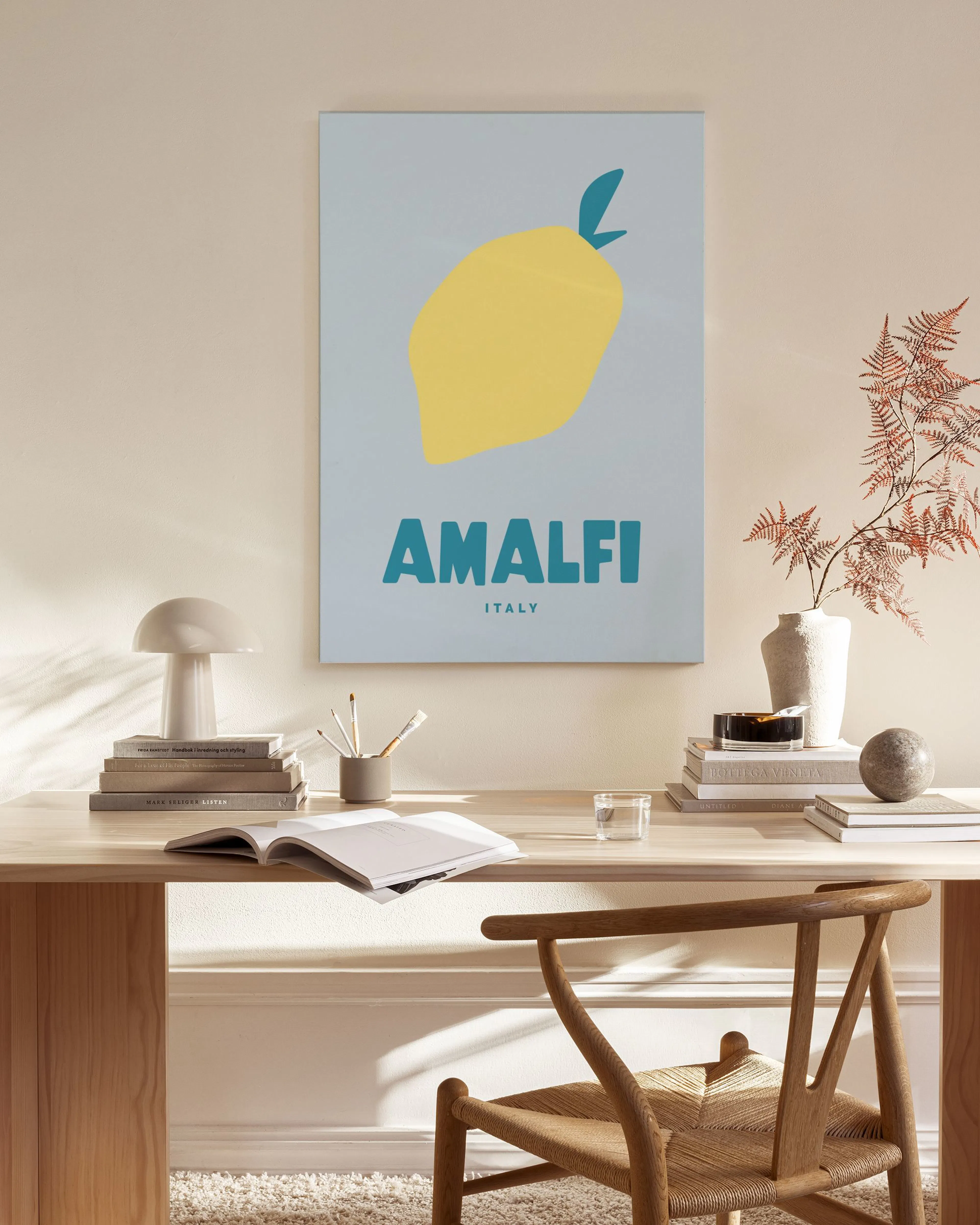Canvas met gele citroen en AMALFI ITALY op lichtblauwe achtergrond, hangend in een neutrale woonkamer.