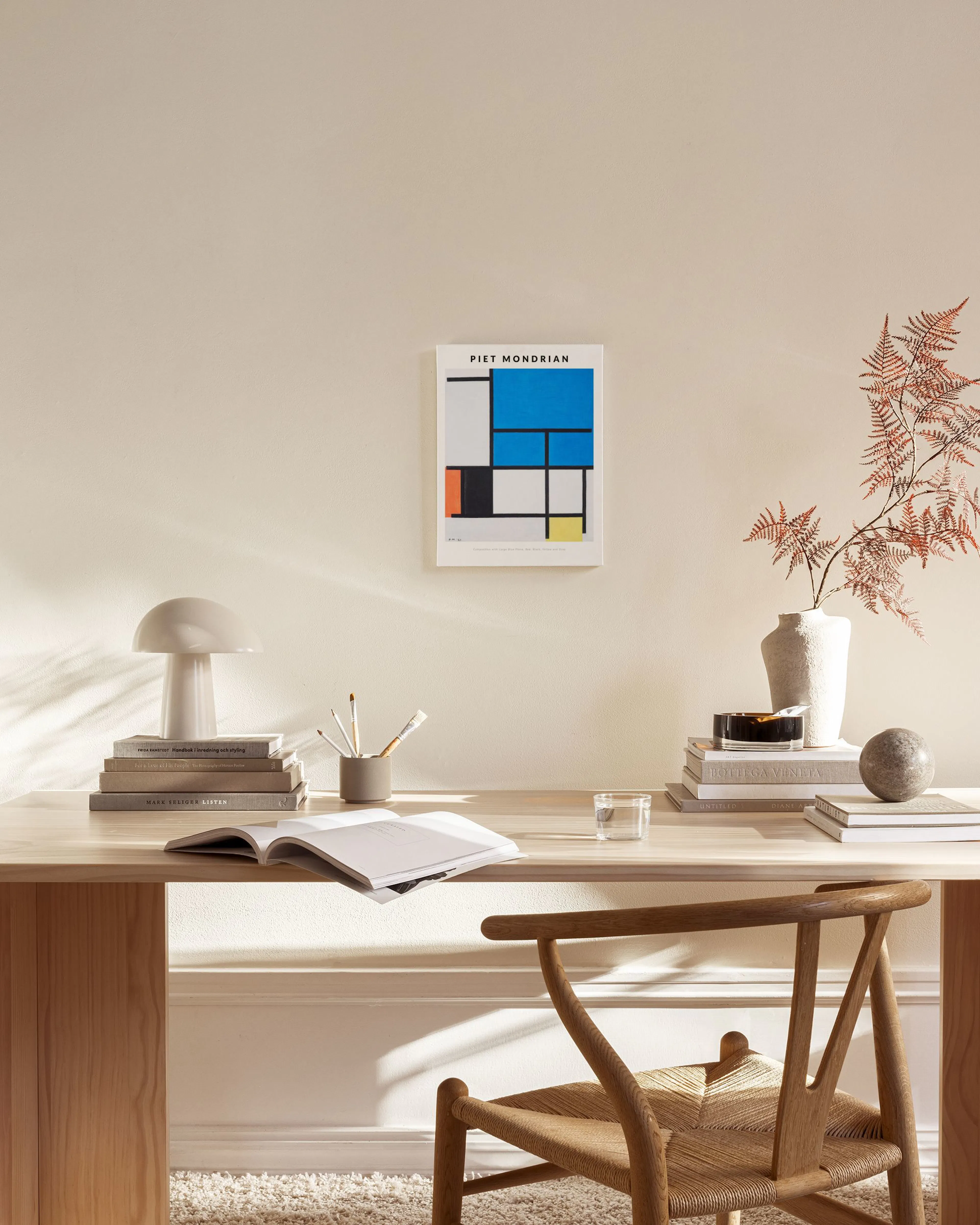 Piet Mondrian -kanvaasi modernissa olohuoneessa valkoisen seinän edessä, puisen lipaston yläpuolella.