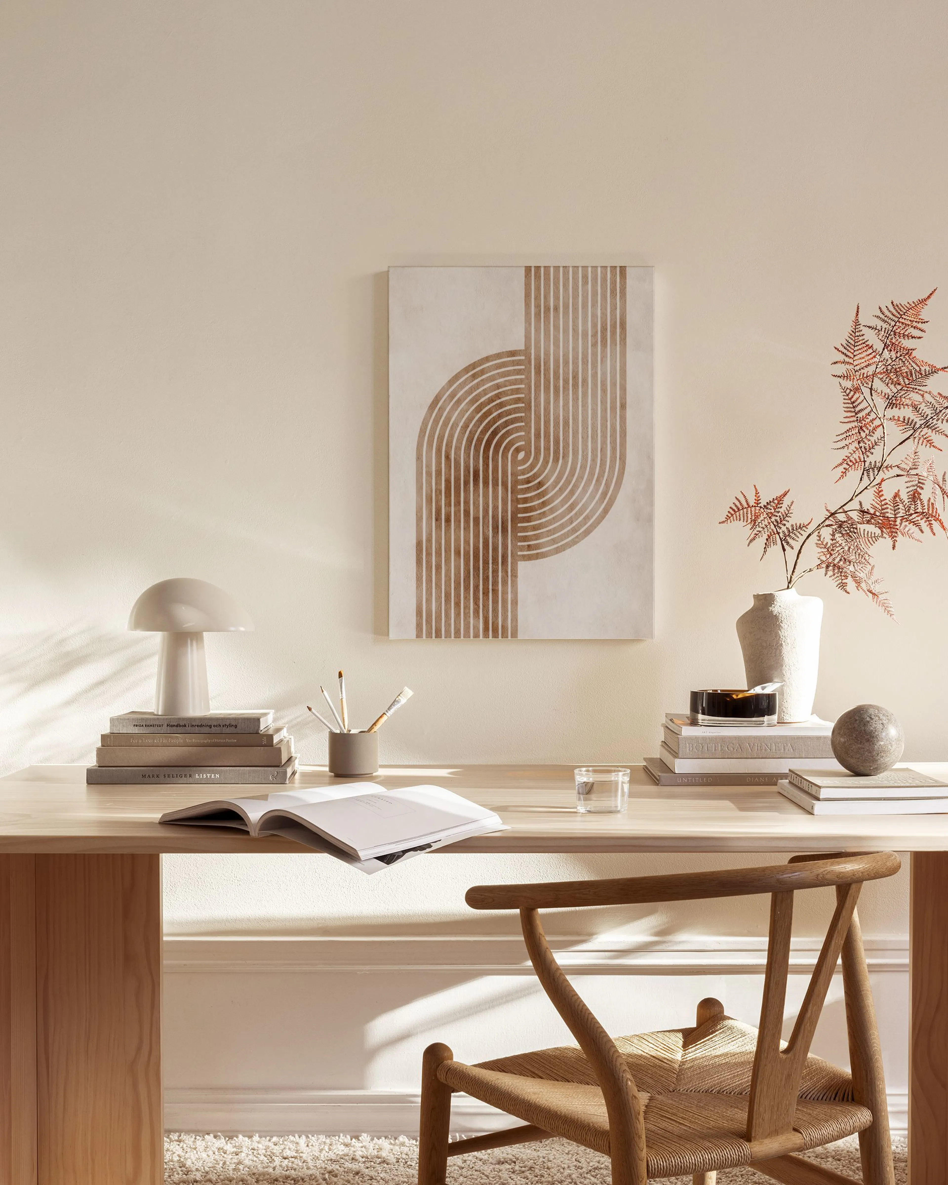 Lienzo con diseño abstracto de formas curvas y líneas verticales en tonos tierra, colgado en una sala de estar.