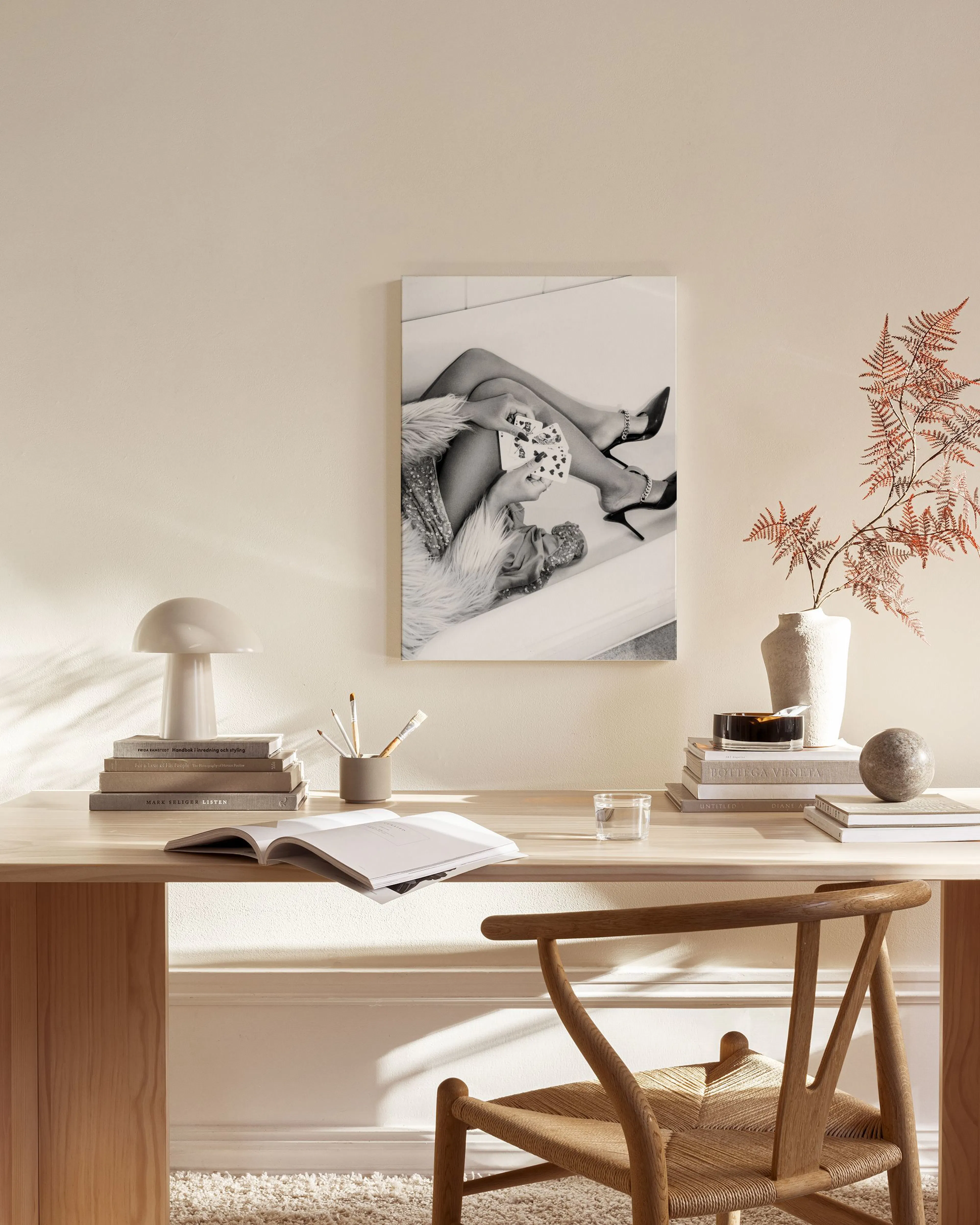 Leinwandbild einer Frau in High Heels mit Spielkarten, liegend auf einem Sofa, in einem modernen Wohnzimmer.