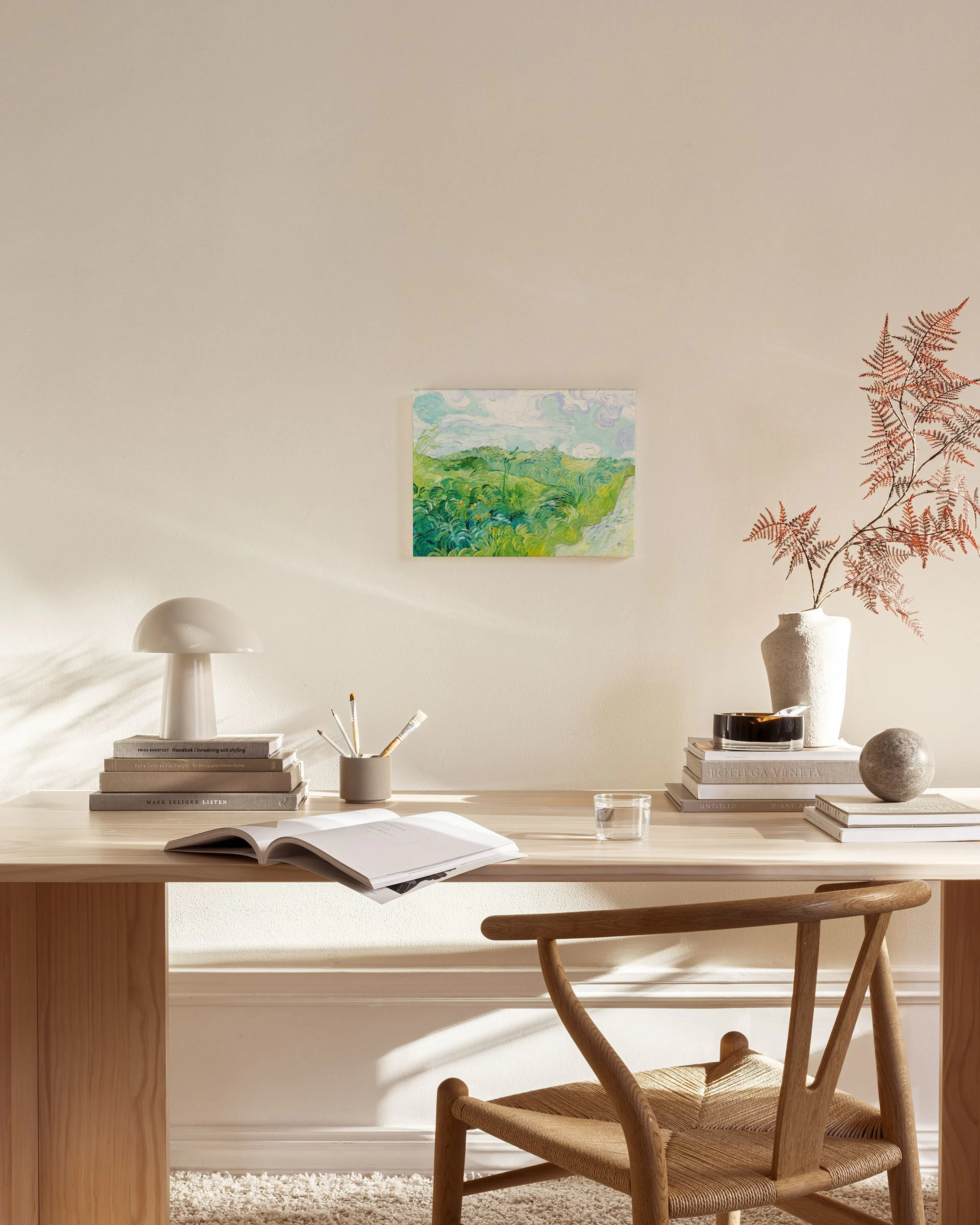 Leinwandbild mit grünem Feld und blauem Himmel, aufgehängt in einem modernen Wohnzimmer über einem Sideboard.