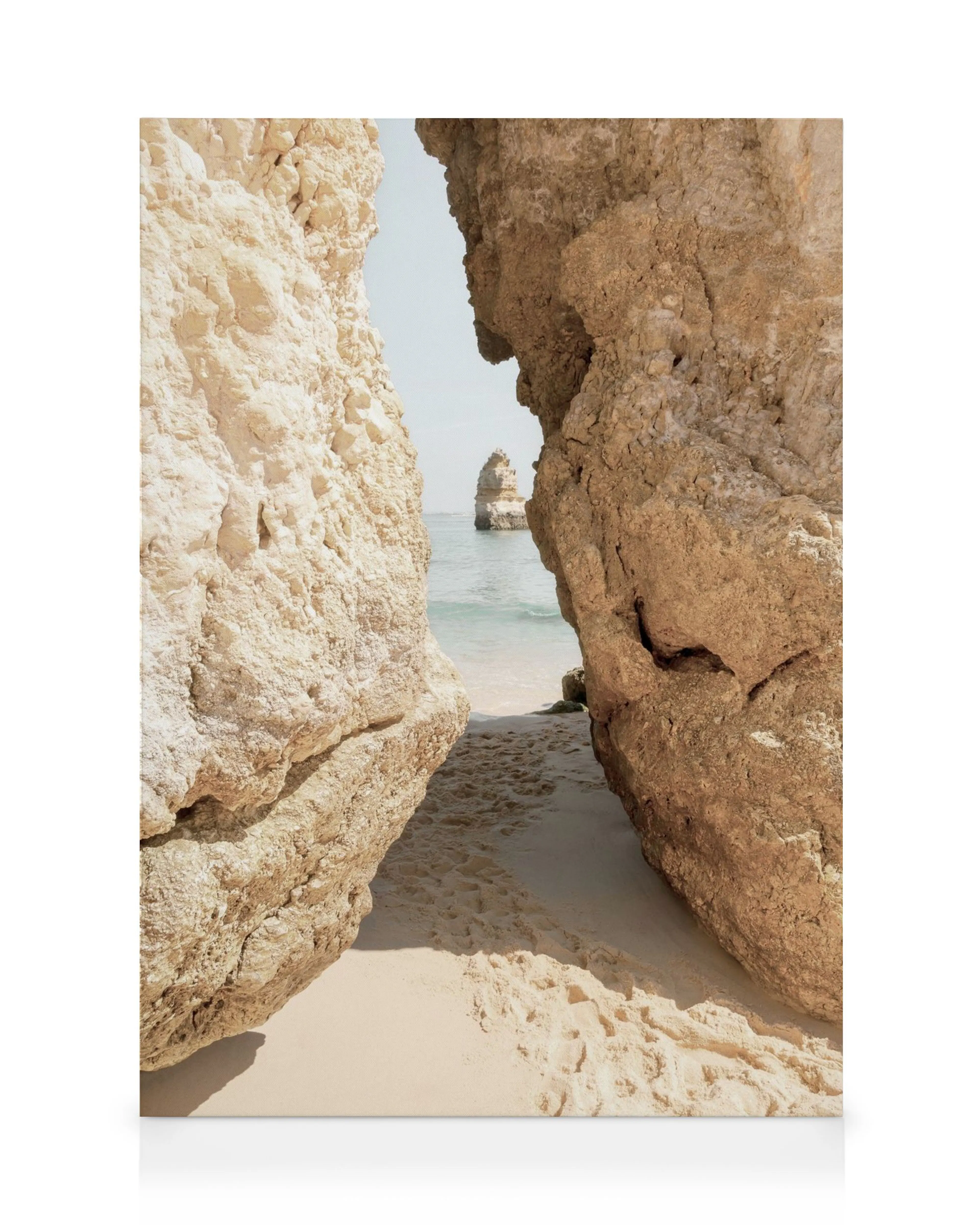 Canvastavla med sandstrand mellan två stora klippor, lugnt hav och klar himmel. Algarve kustlandskap, strandmotiv.