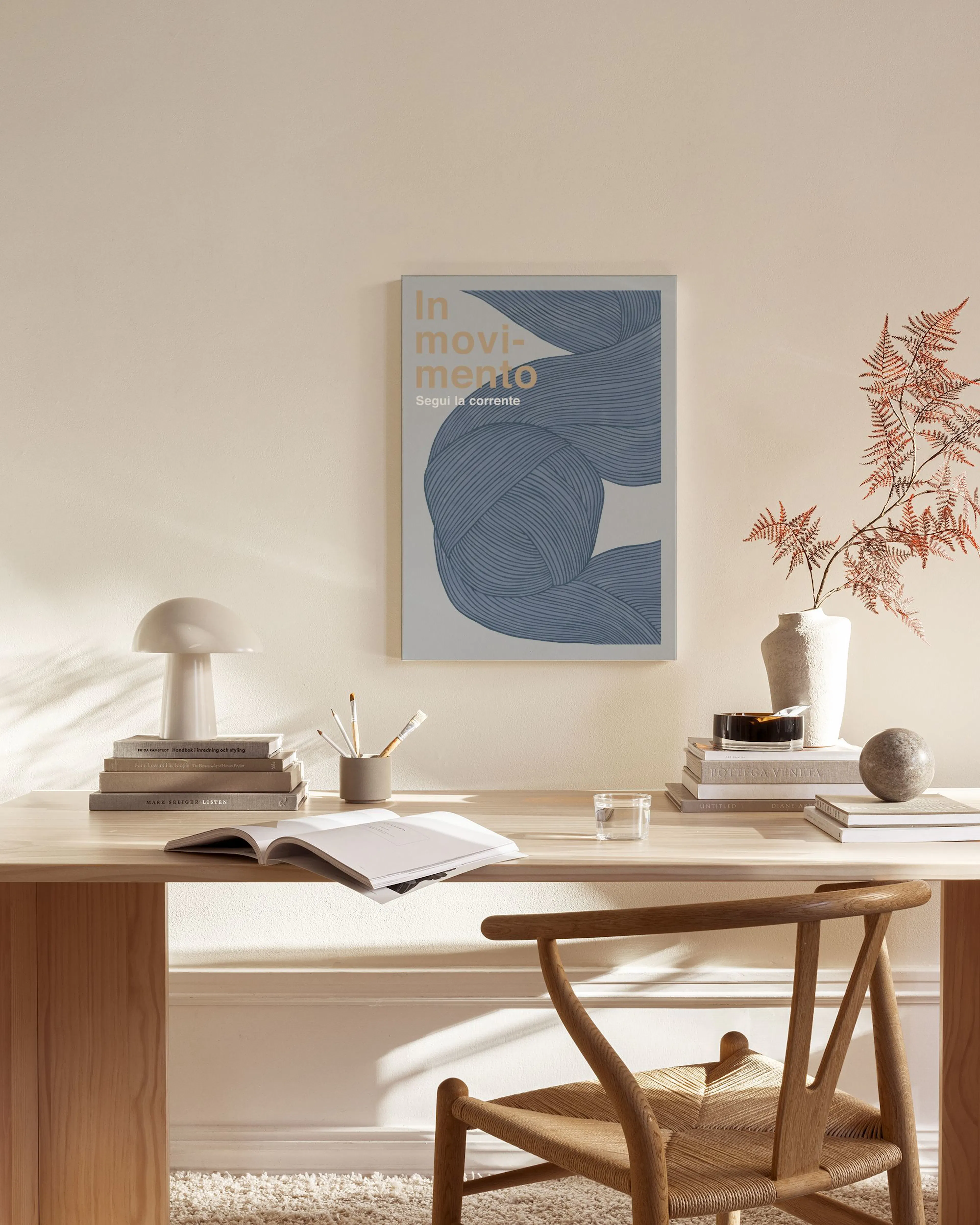 Canvas met golvende blauwe lijnen en beige tekst In Movimento Segui la Corrente, hangend in een lichte woonkamer.