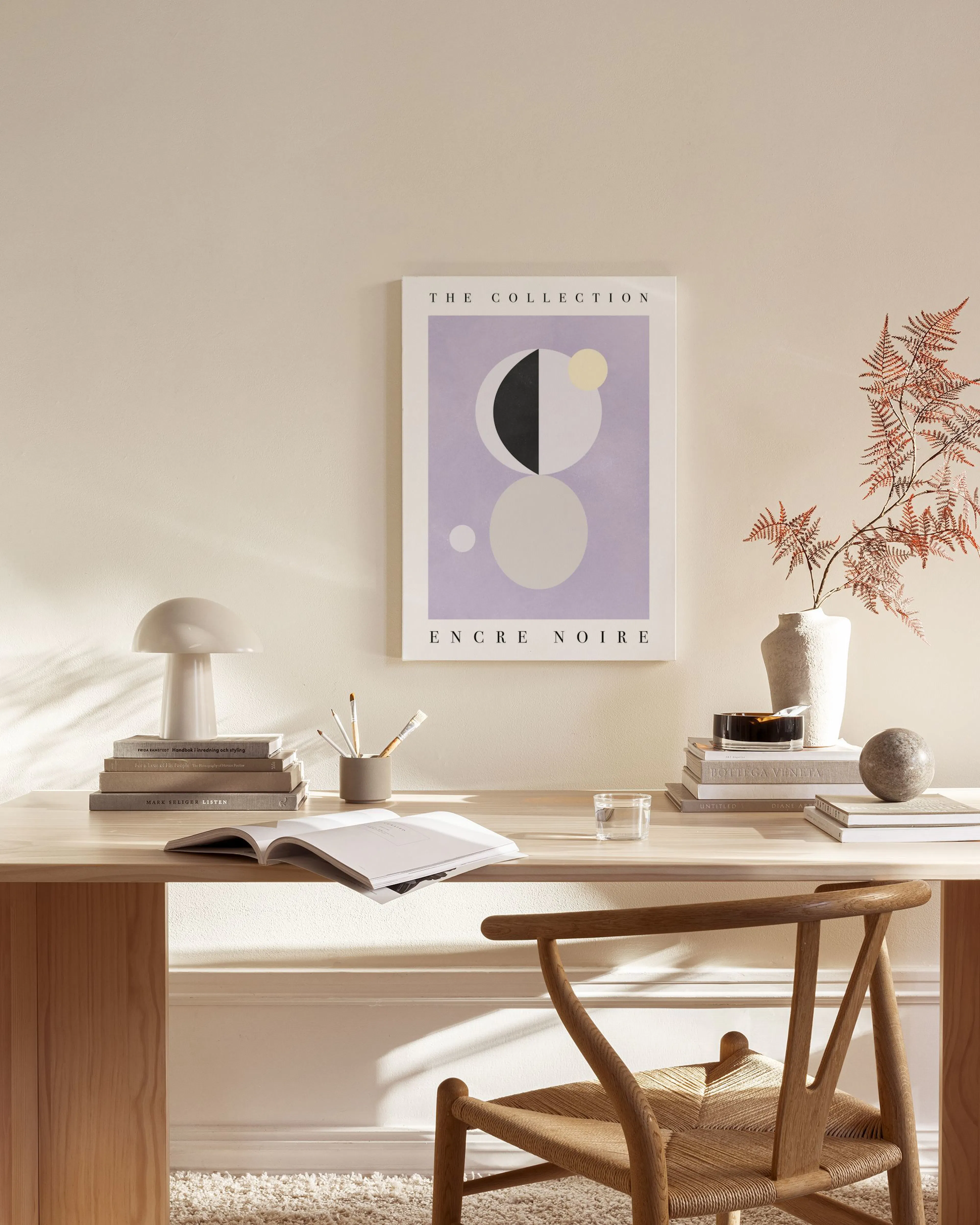 Lienzo abstracto de formas geométricas en lavanda, gris, negro y amarillo pálido, colgado en una sala moderna.