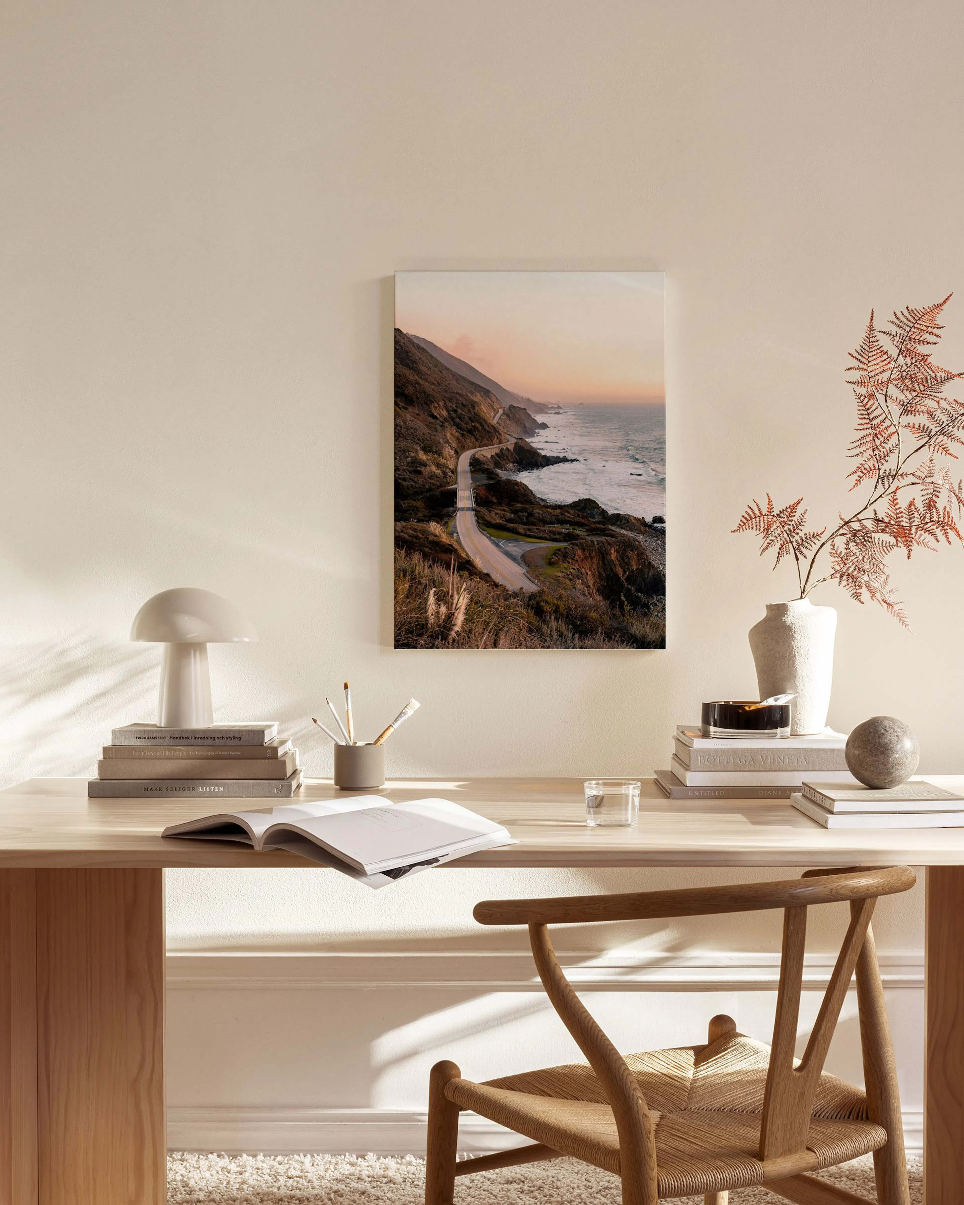 Leinwandbild einer Küstenstraße bei Sonnenuntergang, hängend im modernen Wohnzimmer über einem Sideboard.