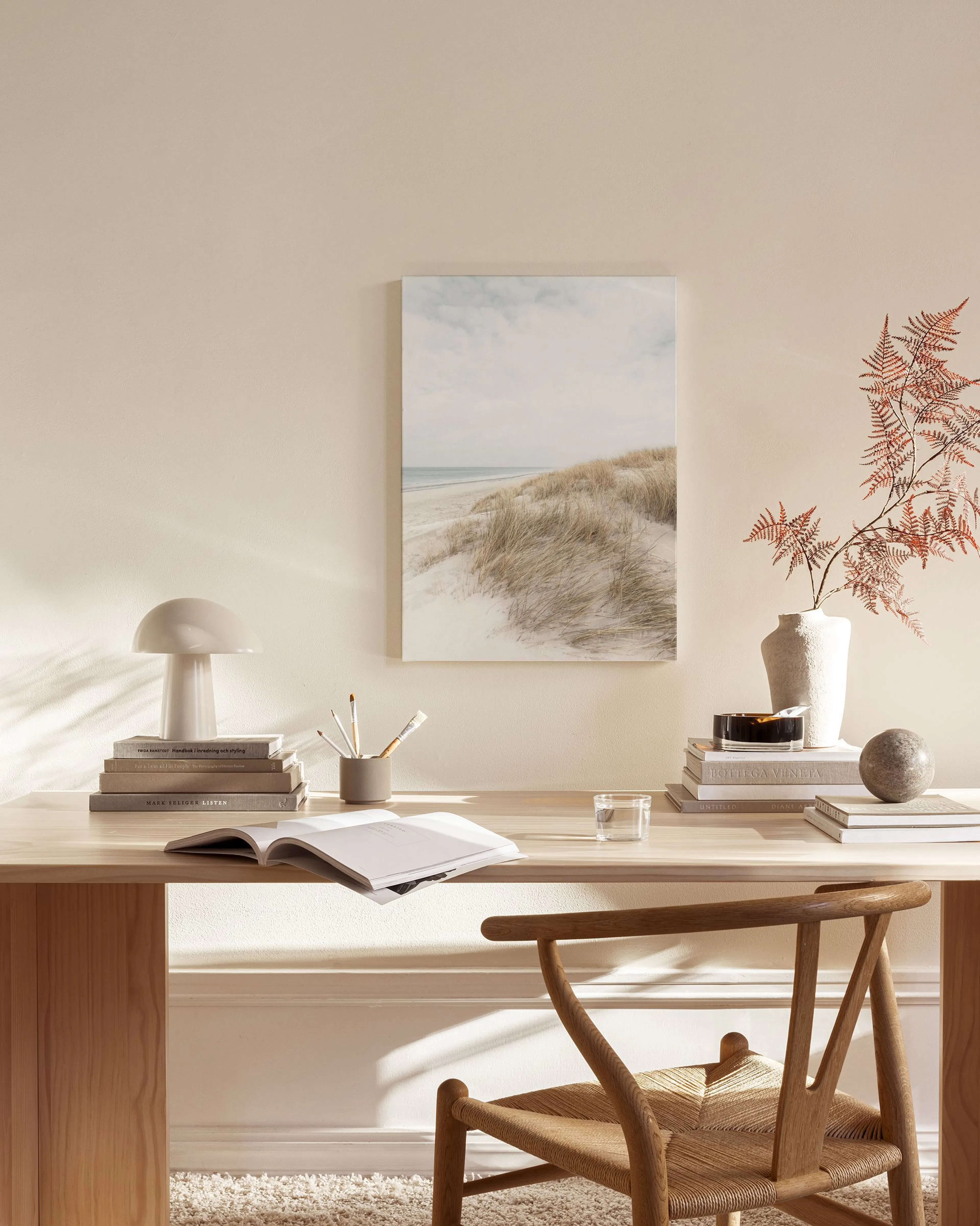 Leinwandbild einer Dünenlandschaft am Meer, darüber ein heller Himmel, in einem modernen Wohnzimmer.