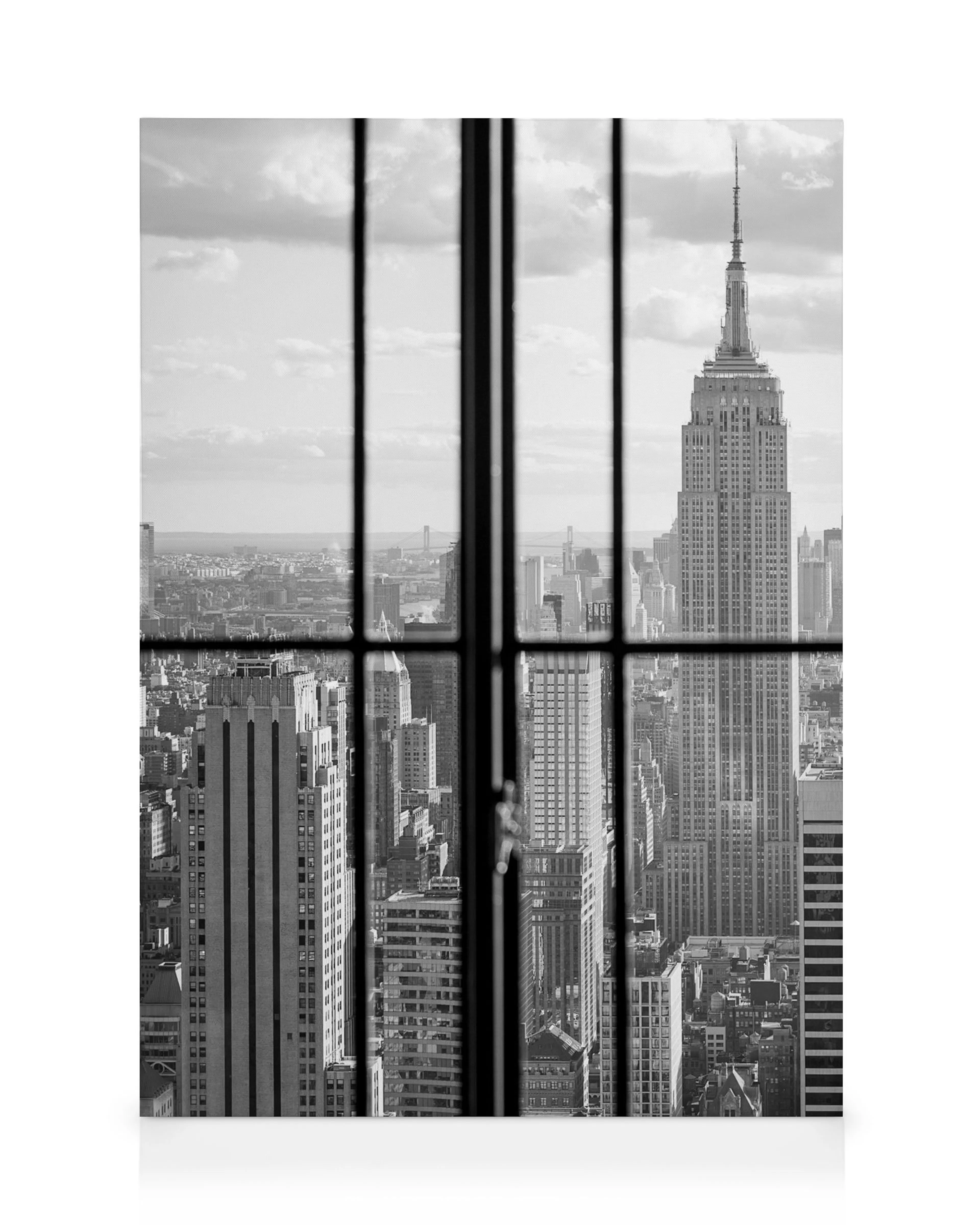 Lienzo blanco y negro de Manhattan visto a través de una ventana, el Empire State Building y la ciudad bajo un cielo nublado.