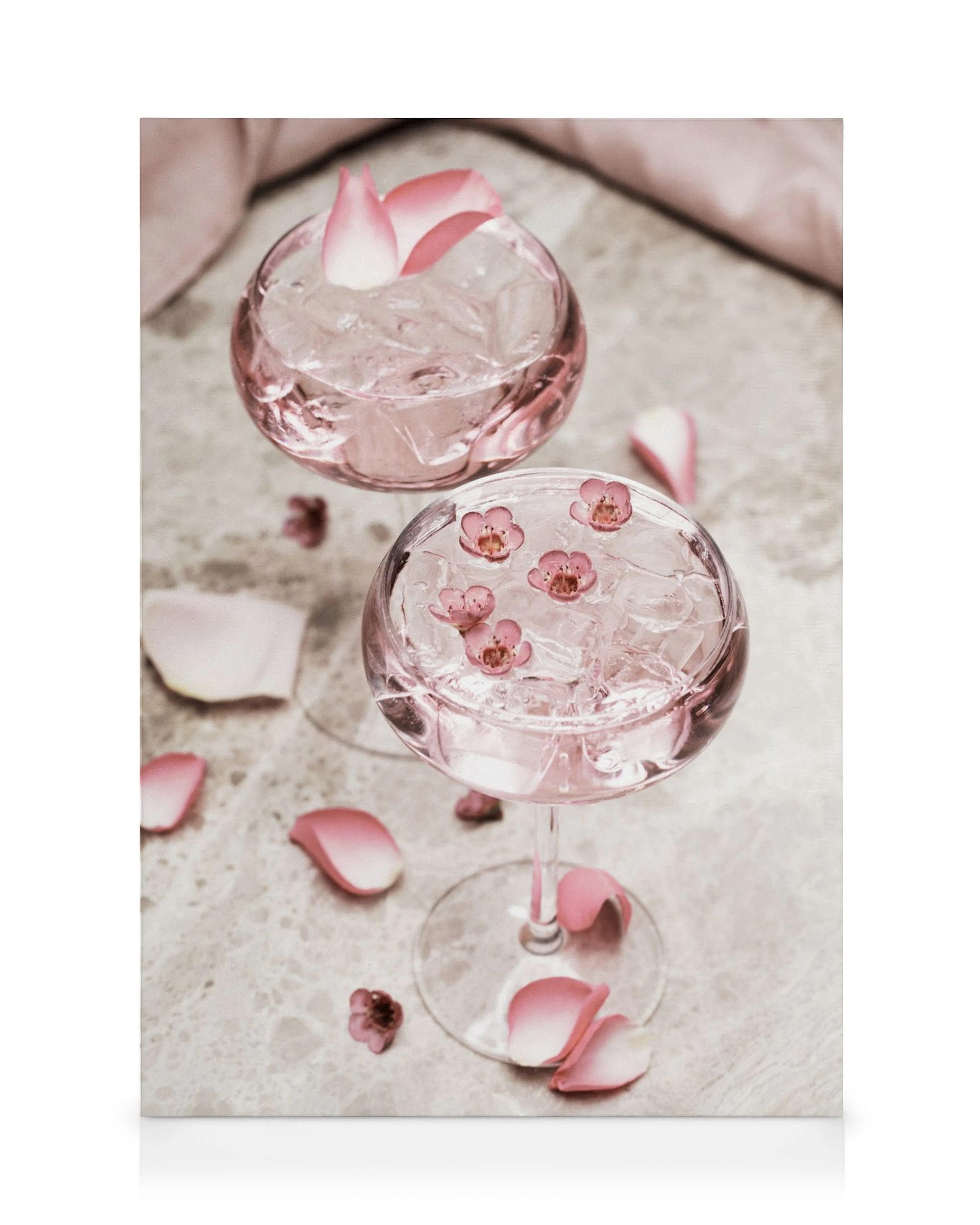 Leinwandbild mit zwei rosa Cocktails, Eiswürfeln, Rosenblättern und Blüten auf Marmorplatte. Romantisches Getränkemotiv.
