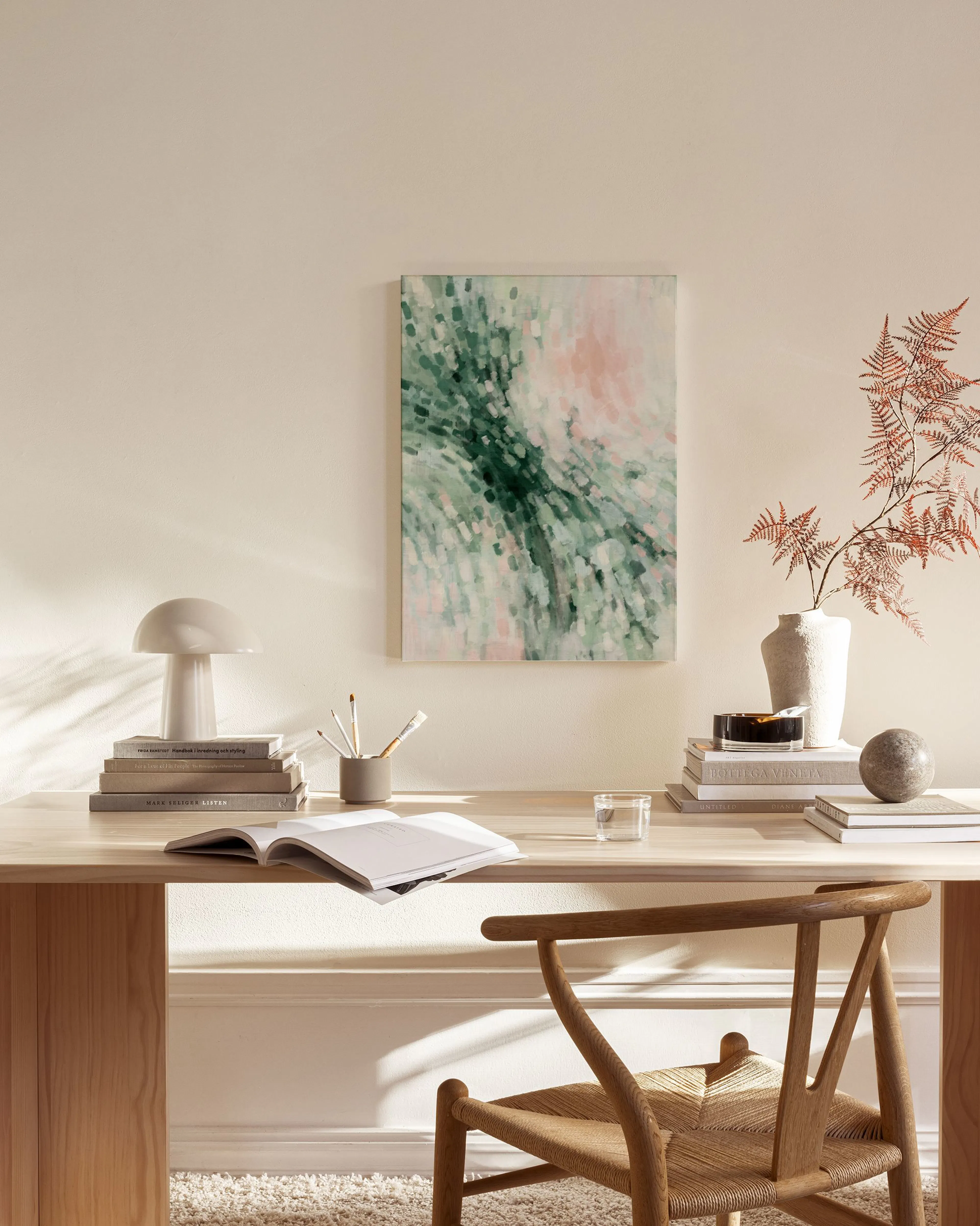 Toile abstraite verte et rose pâle, avec des coups de pinceau fluides, affichée dans un salon moderne.