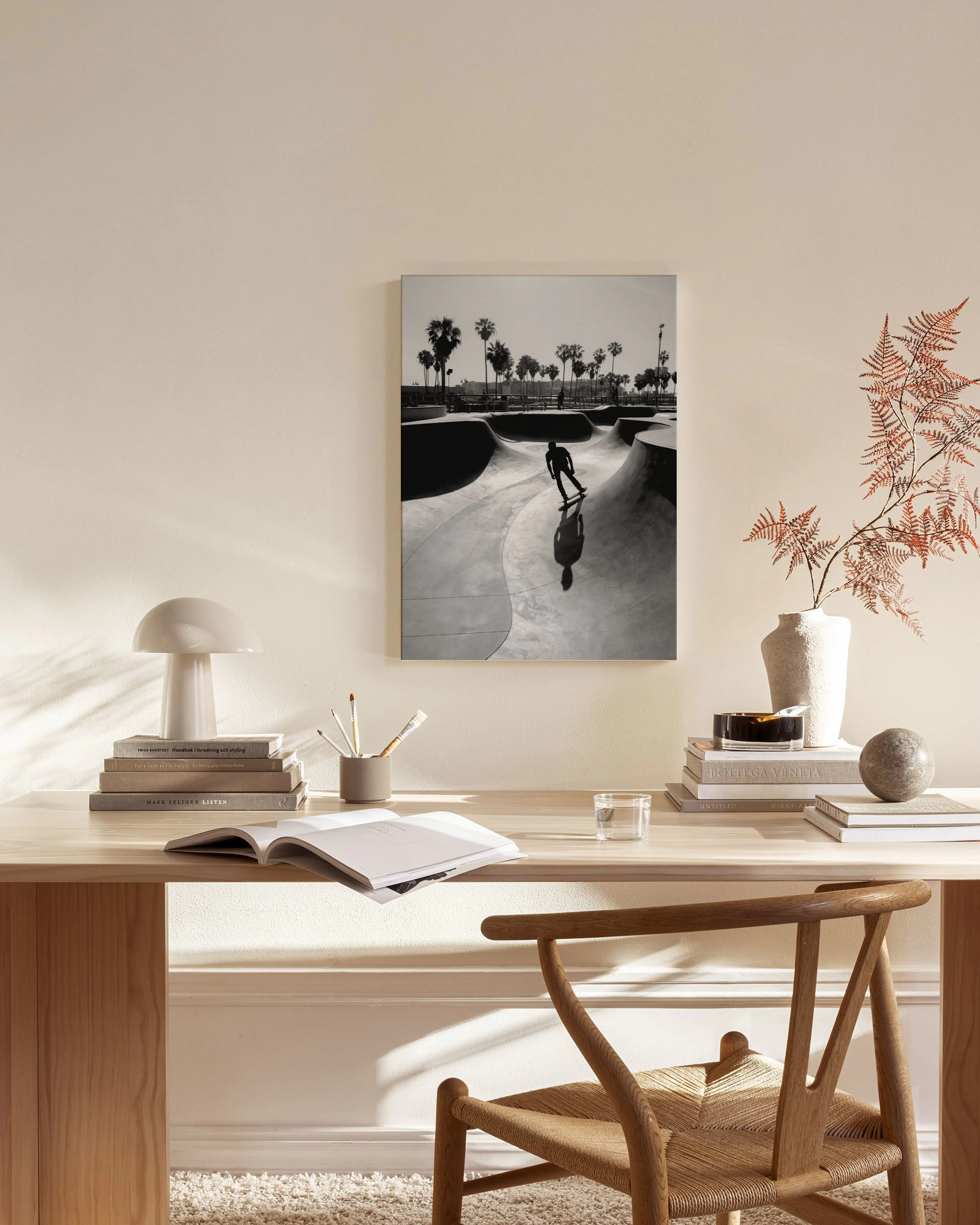 Black and white canvas print of a skateboarder in a skatepark with palm trees, displayed in a minimal living room.