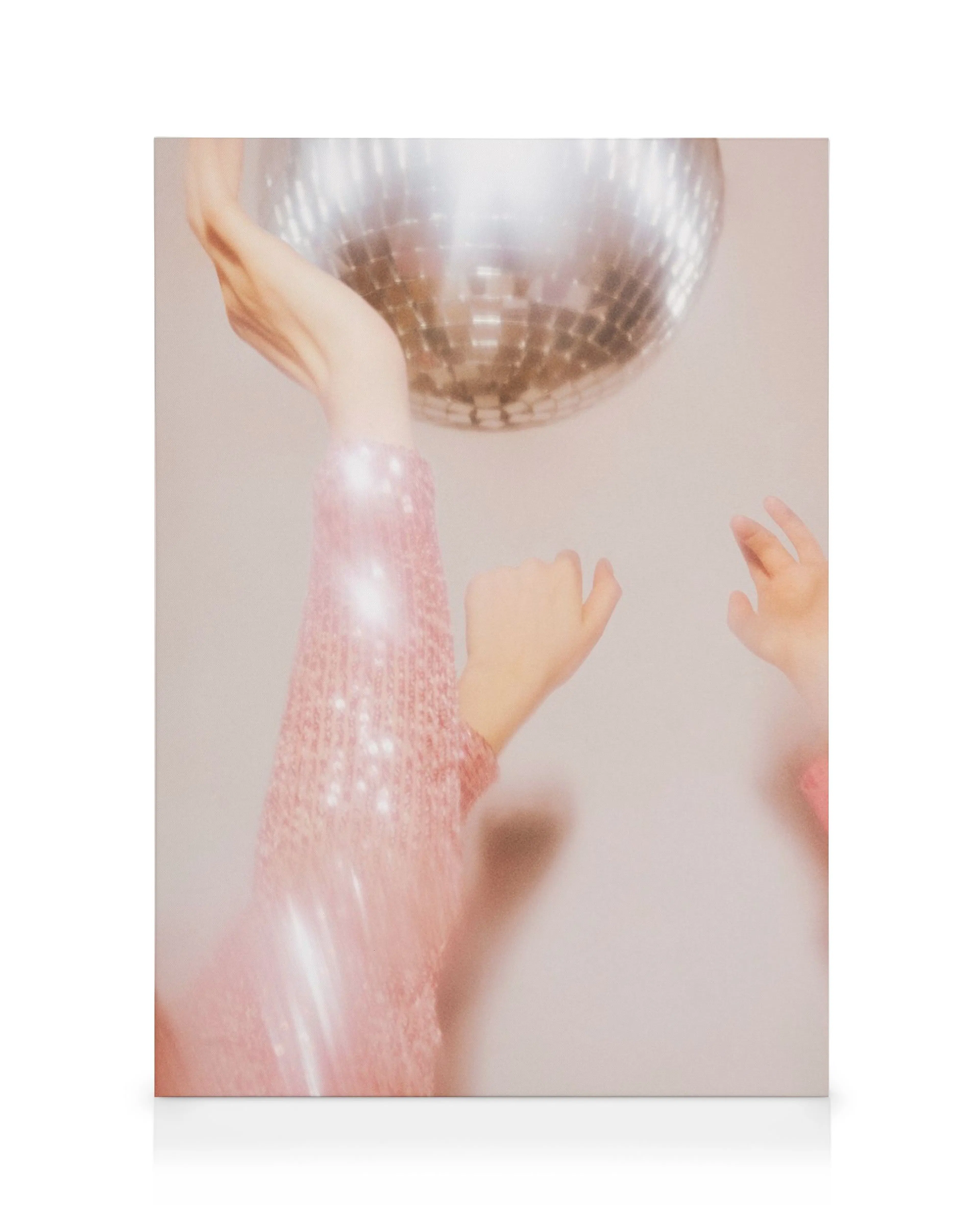Sparkly pink sleeves reaching for a spinning disco ball canvas print with motion blur.