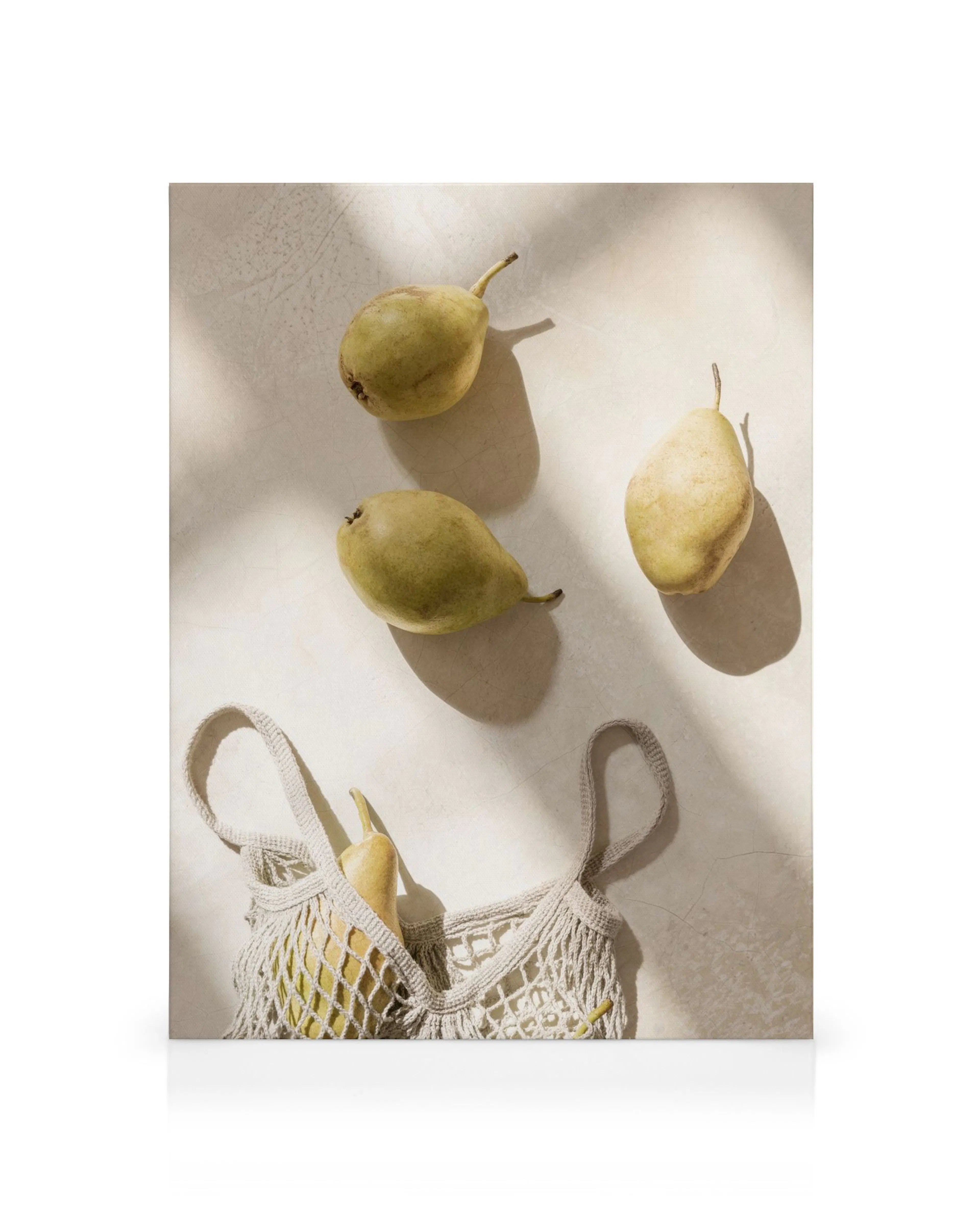 Toile de poires vertes et beiges sur une table, lune dans un sac en filet. Typographie de fruit.