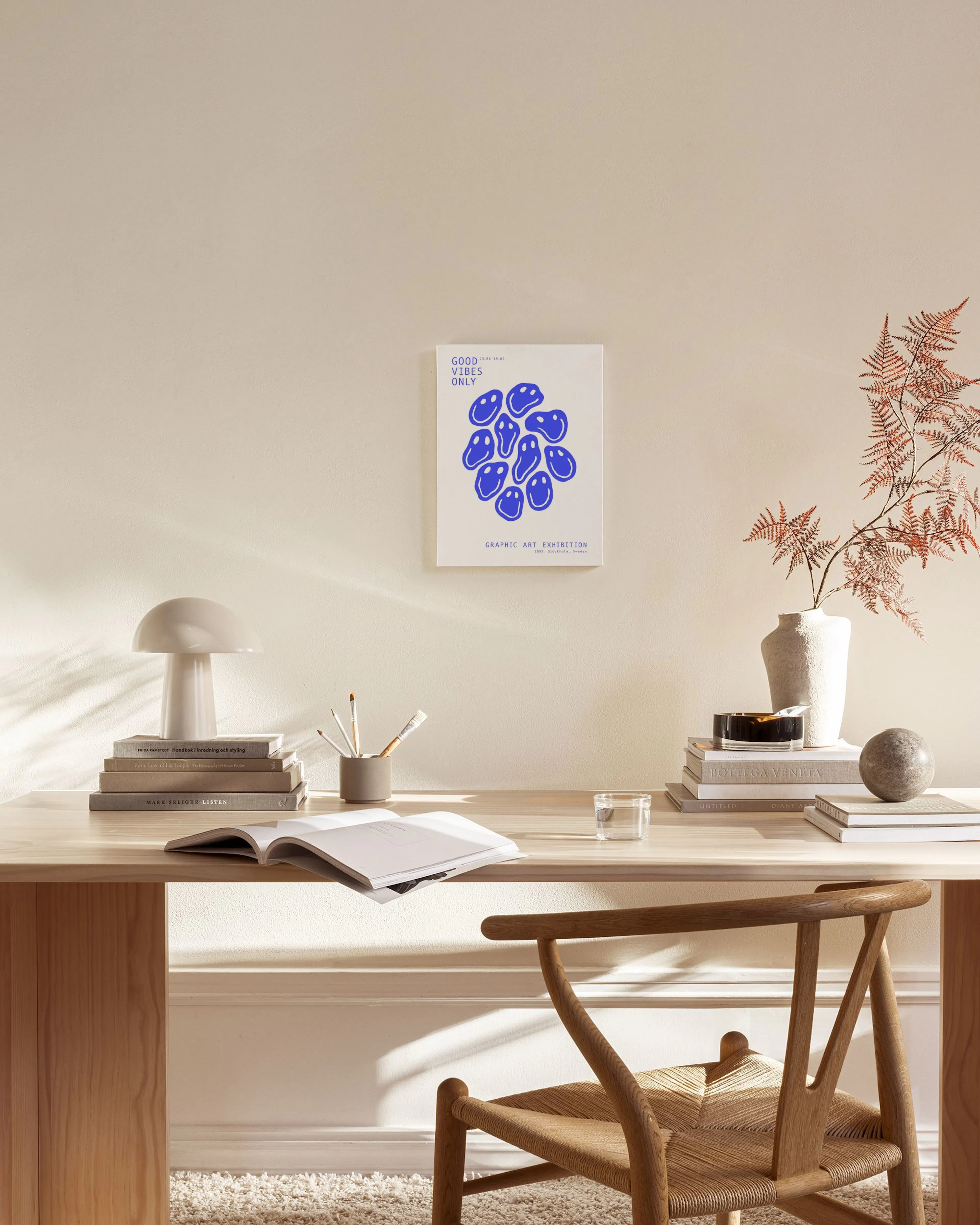 Stampa su tela con faccine blu distorte e scritte, appesa sopra una panca in legno in un soggiorno moderno.