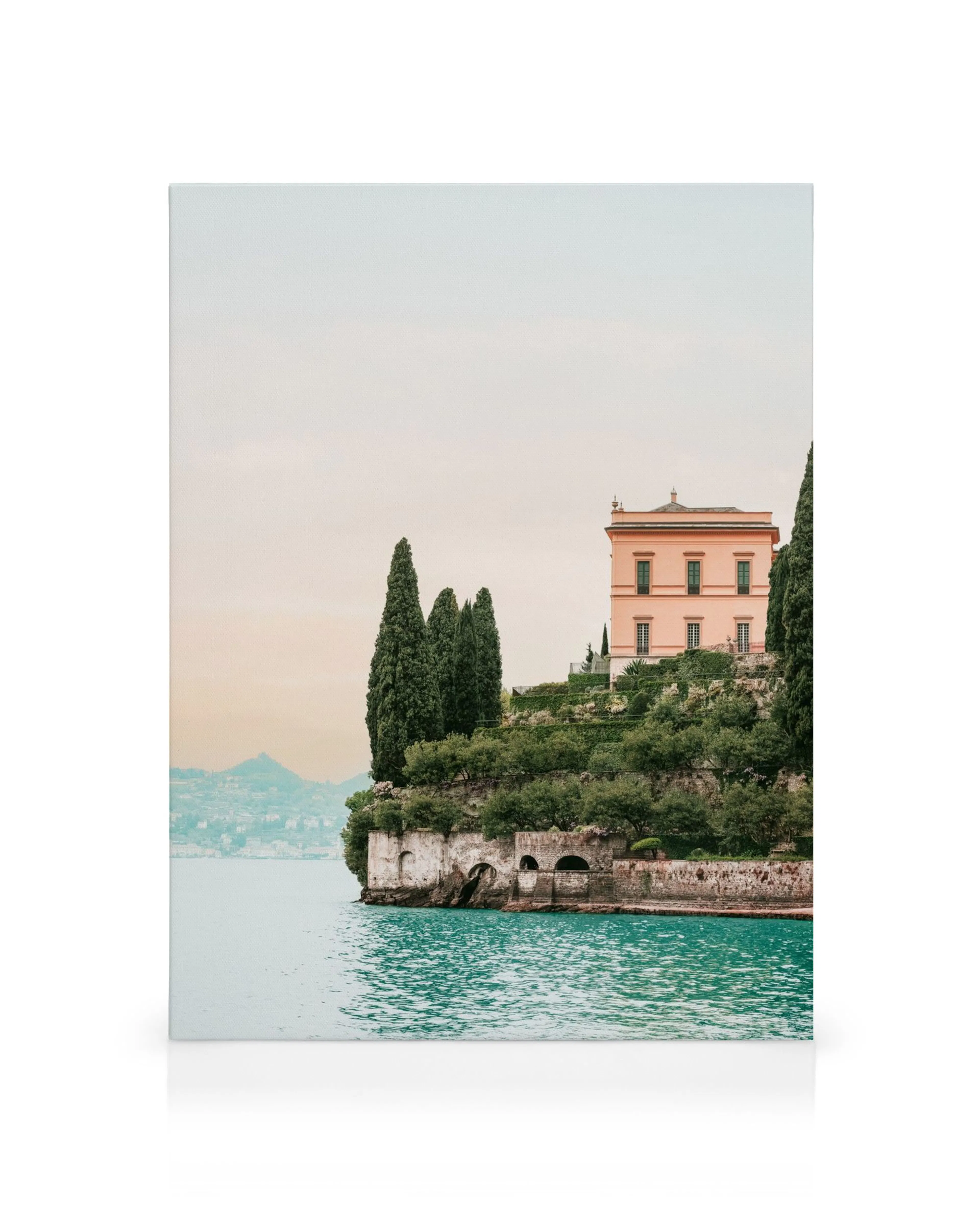 Villa Cipressi herrgård vid Comosjön, Italien. En rosa villa omgiven av gröna cypresser och trädgårdar, med sjön i förgrunden.