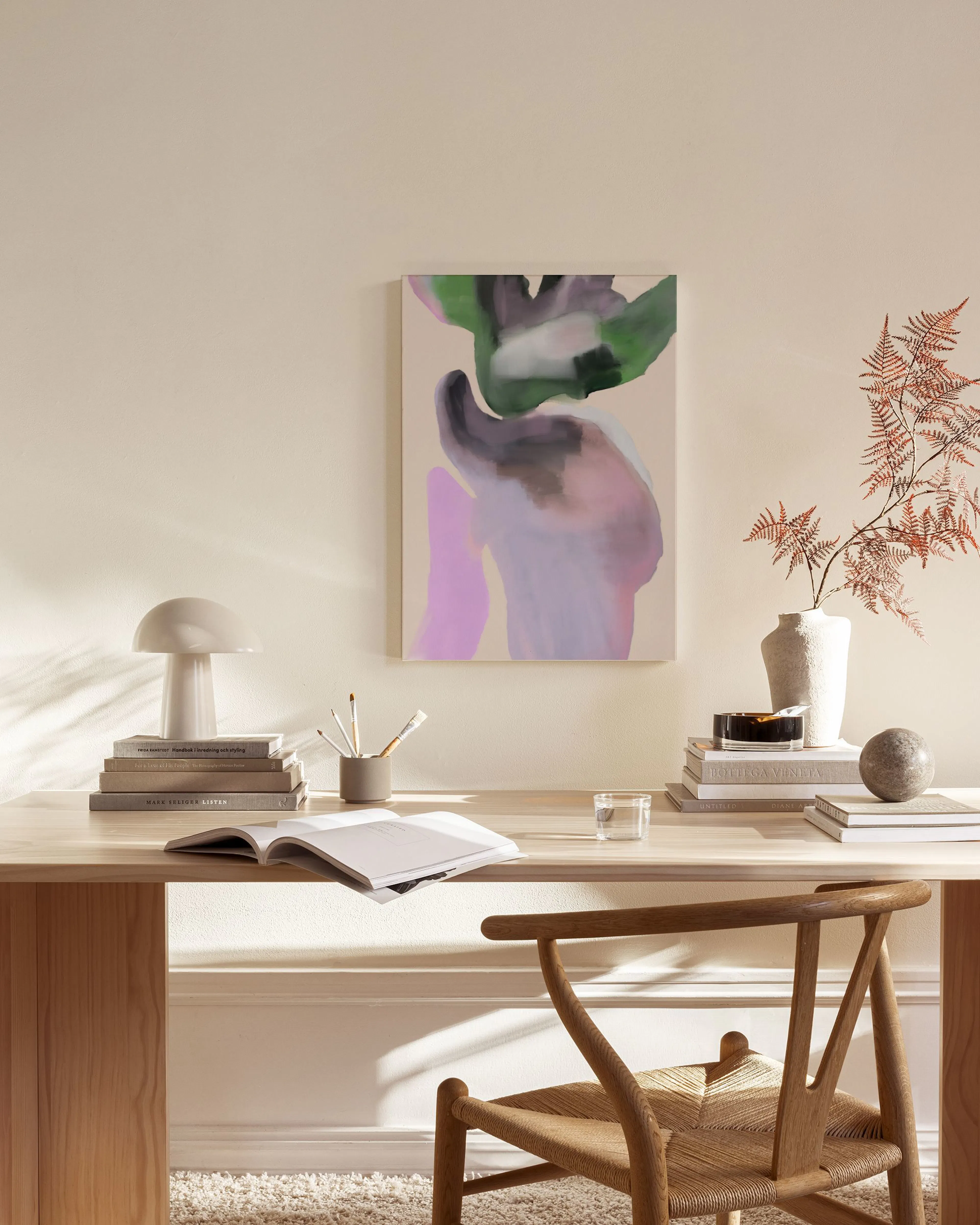 Leinwandbild mit abstrakten Formen in Lila, Grün und Grau, hängend im Wohnzimmer über einem Sideboard.