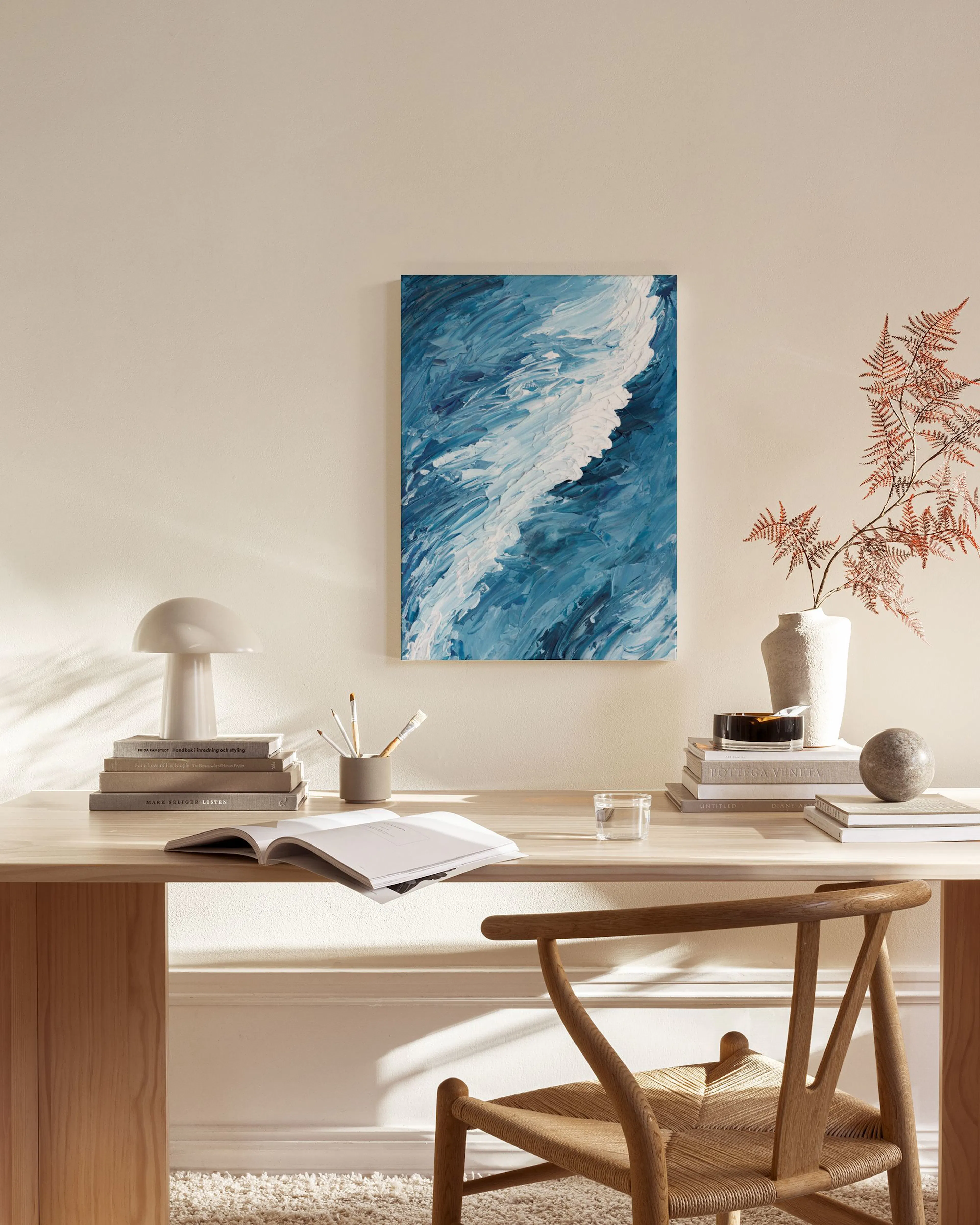 Leinwandbild mit blauen und weißen Wellenformen, hängend über einem Sideboard in einem modernen Wohnzimmer.