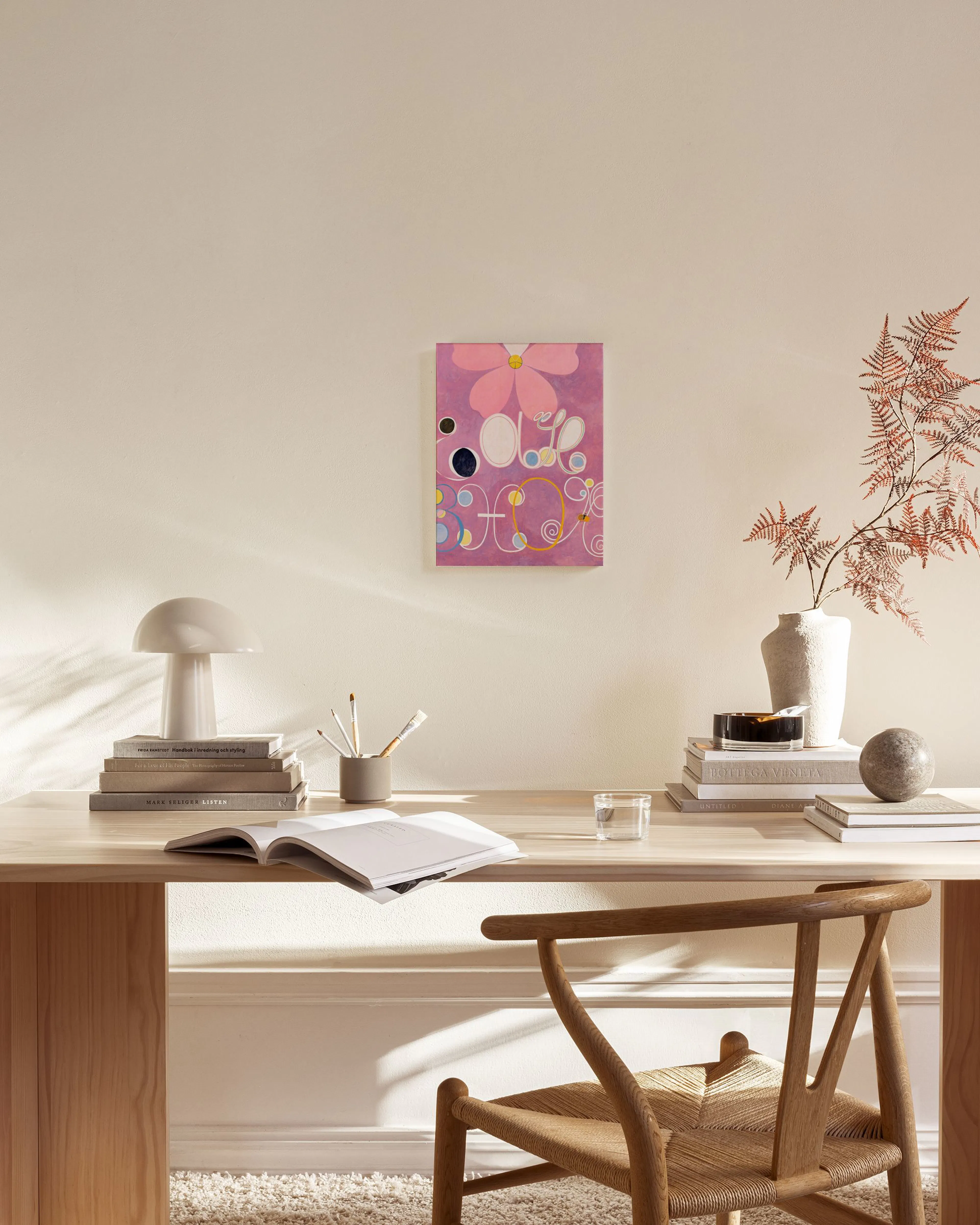 Abstract canvas print with a large pink flower and swirling shapes on a purple background, displayed in a living room.