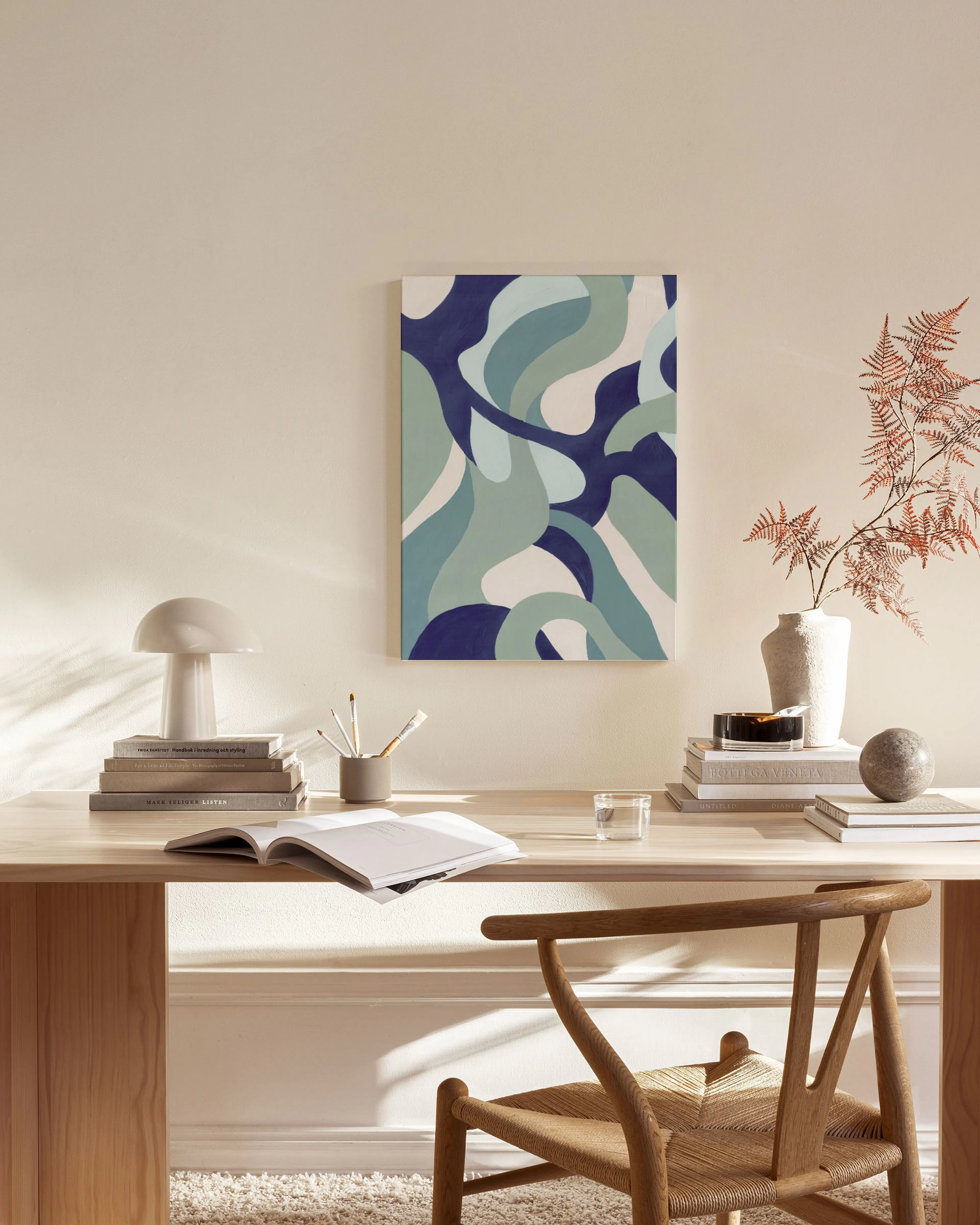 Leinwandbild mit blauen, türkisen und hellblauen organischen Formen, hängt in einem modernen Wohnzimmer über einem Sideboard.