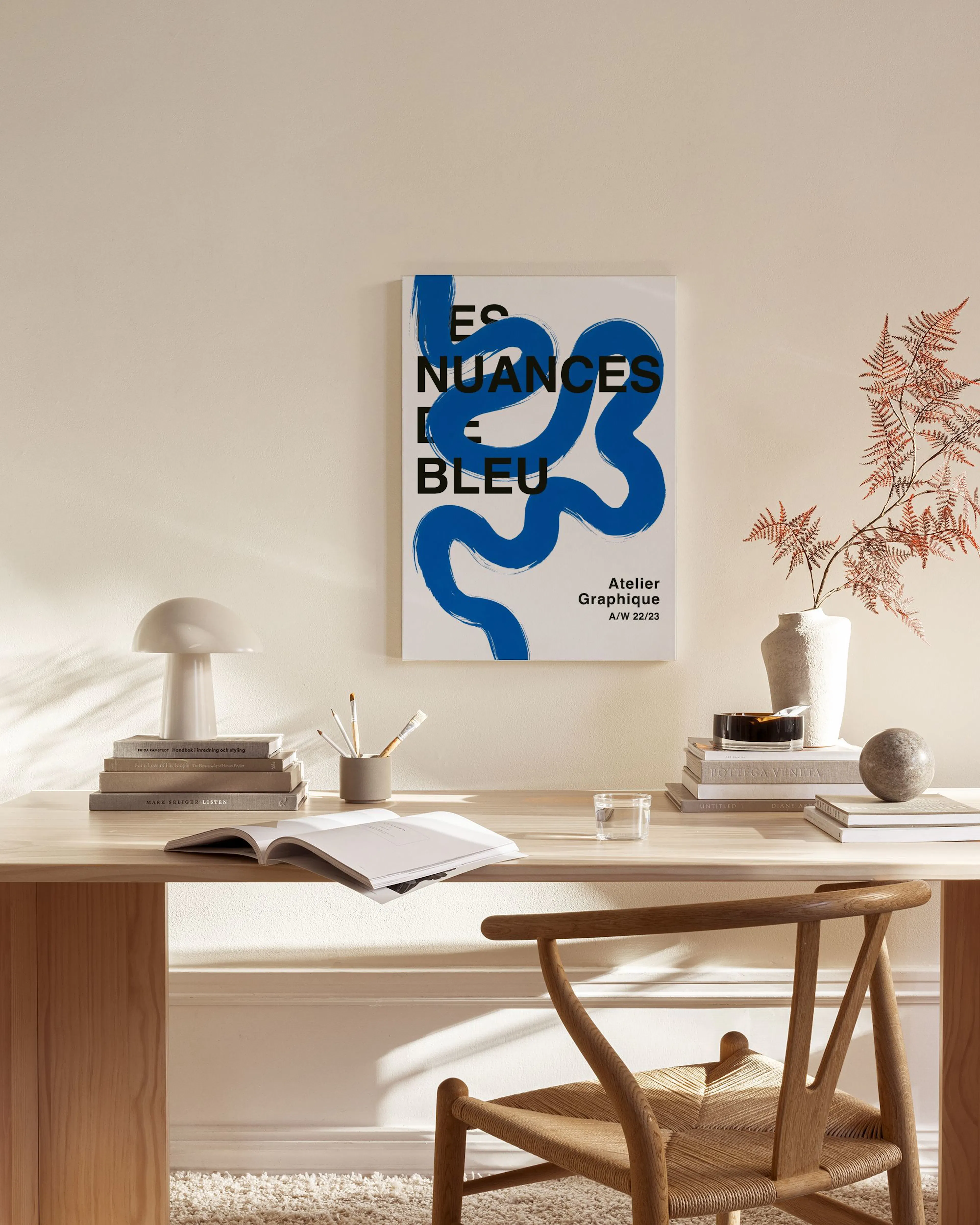 Blue abstract brushstroke art with Les Nuances de Bleu text, hanging in a minimalist living room.