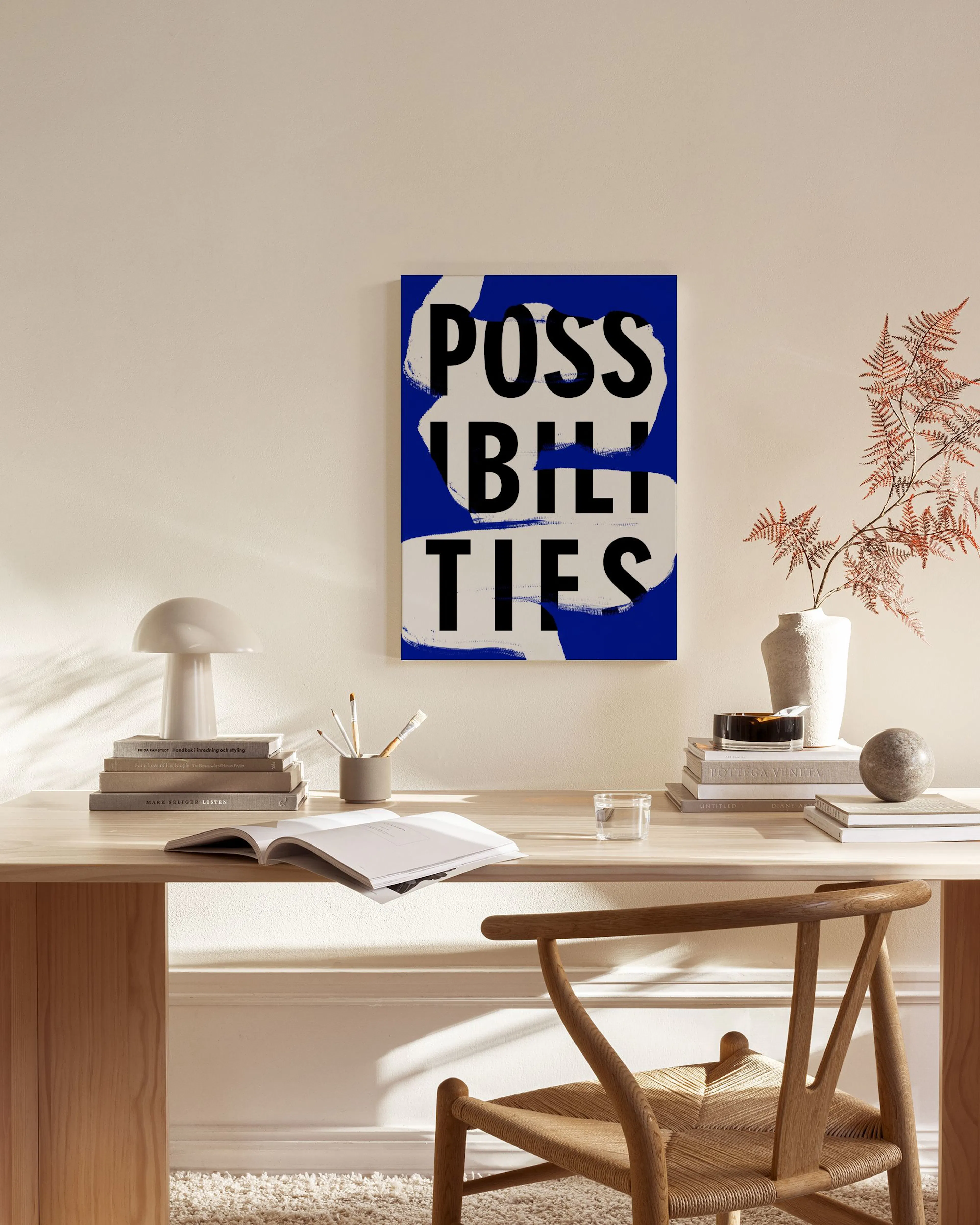 Canvas met blauwe achtergrond en witte penseelstreken, met de zwarte tekst POSSIBILITIES, hangend in een moderne woonkamer.