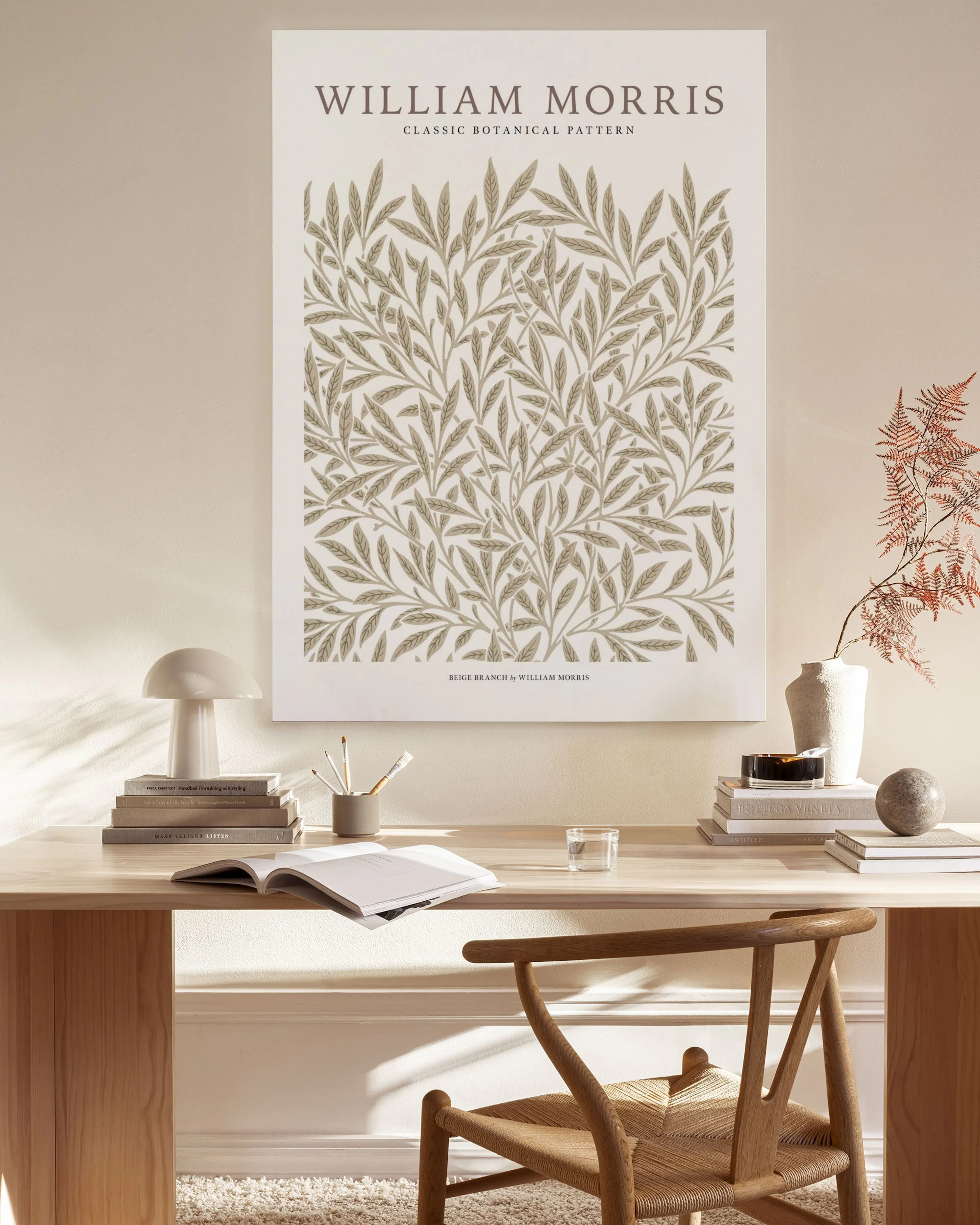A beige botanical pattern with delicate leaves and branches by William Morris on a white background.