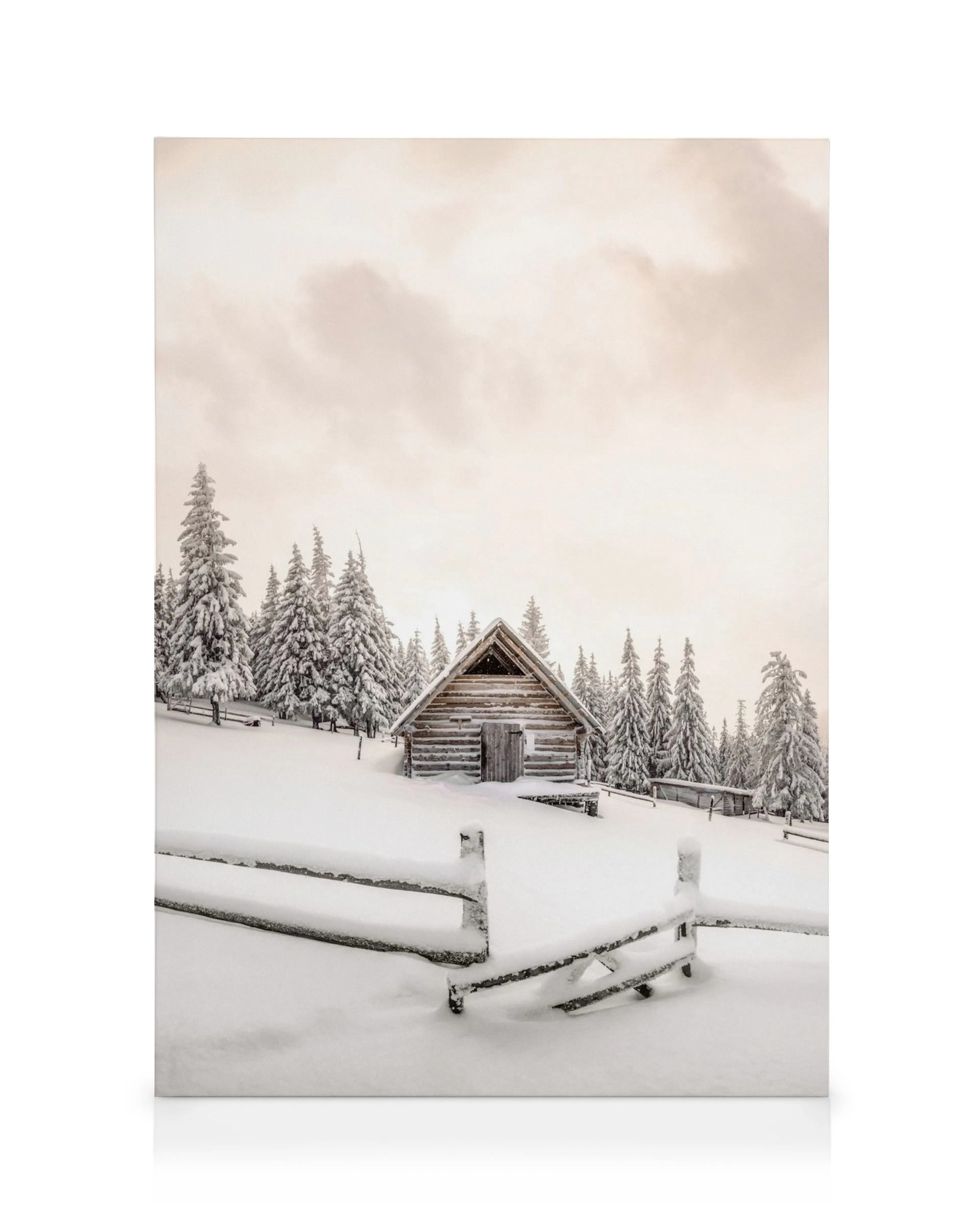 Snowy cabin canvas print of a rustic log cabin nestled among snow-covered pine trees, with a snow-laden fence in the foreground 