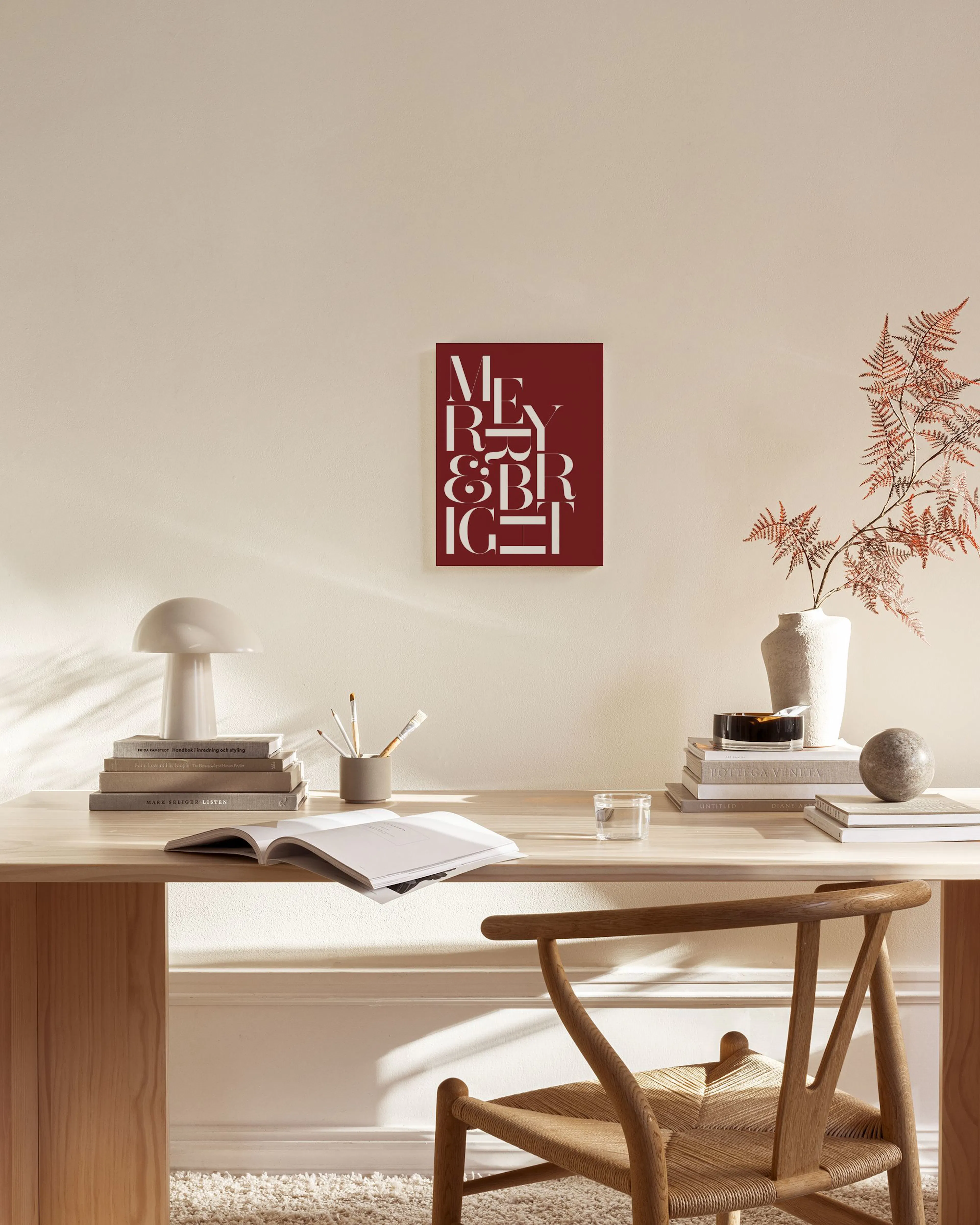 Red and white Merry & Bright typography canvas, hanging in a modern living room above a wooden console table.