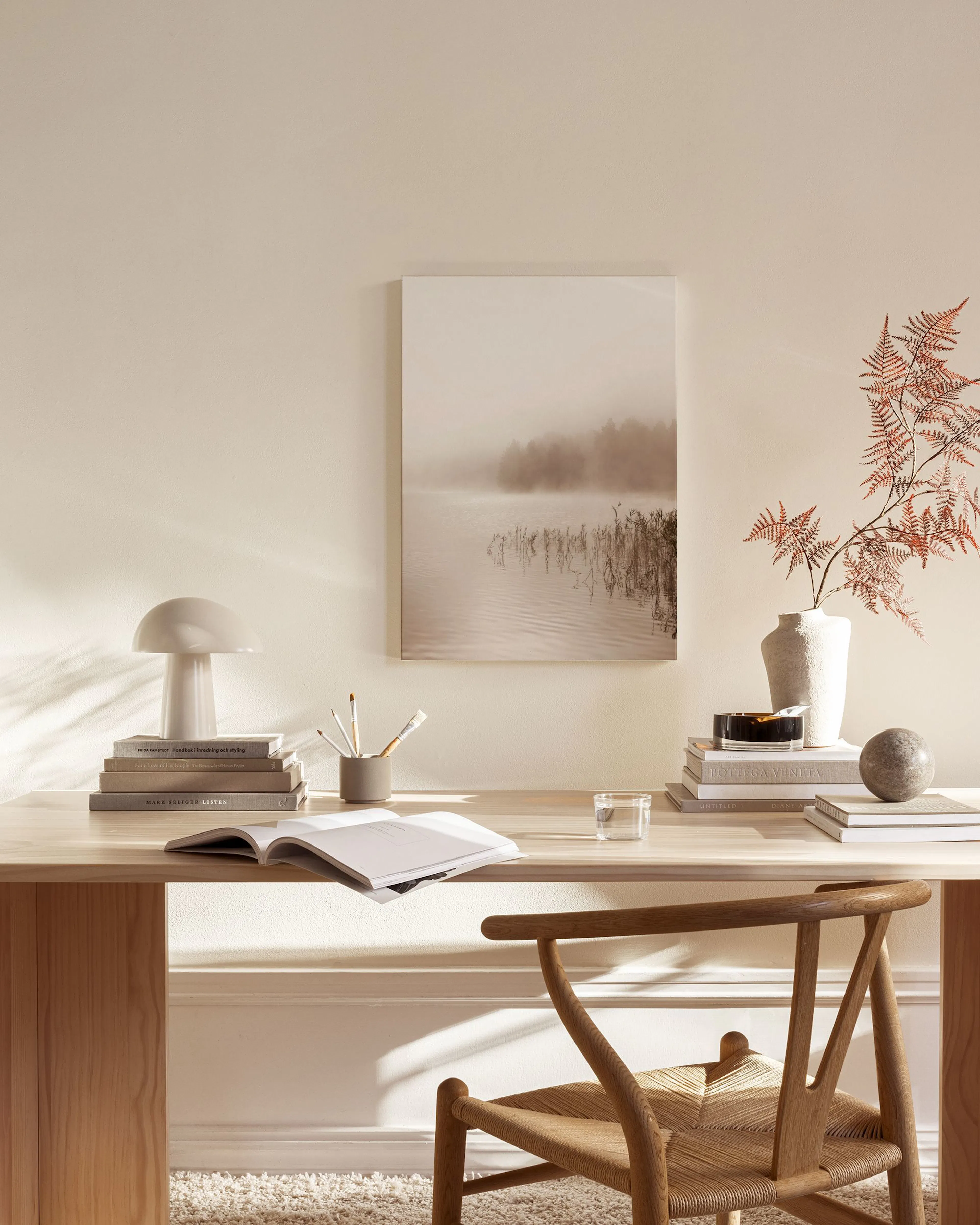 Canvas van een mistig meer met riet en bomen op de achtergrond, hangend in een neutrale woonkamer.