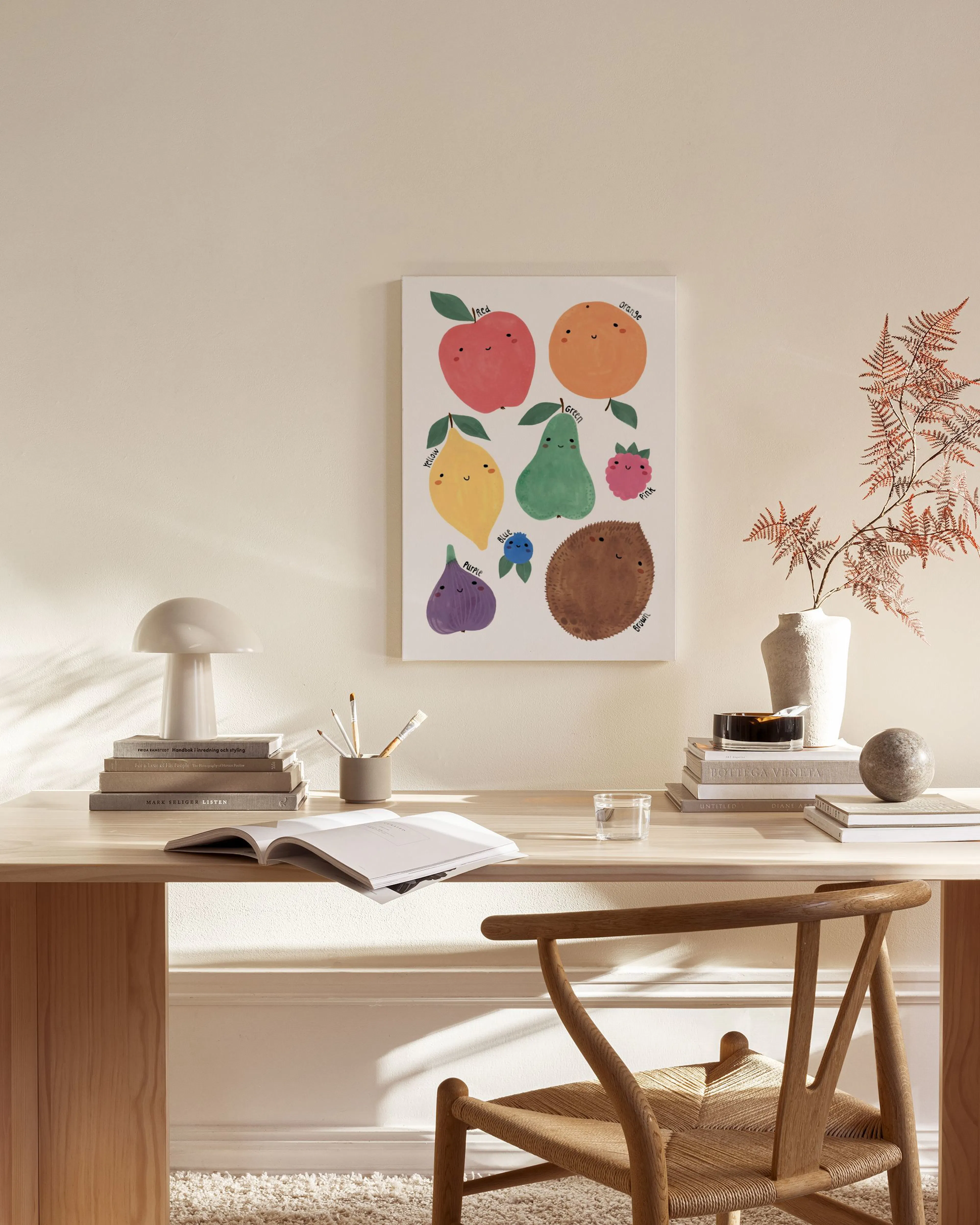 Toile murale de fruits souriants aux couleurs vives, exposée dans un salon moderne avec fauteuil en bois et table basse.