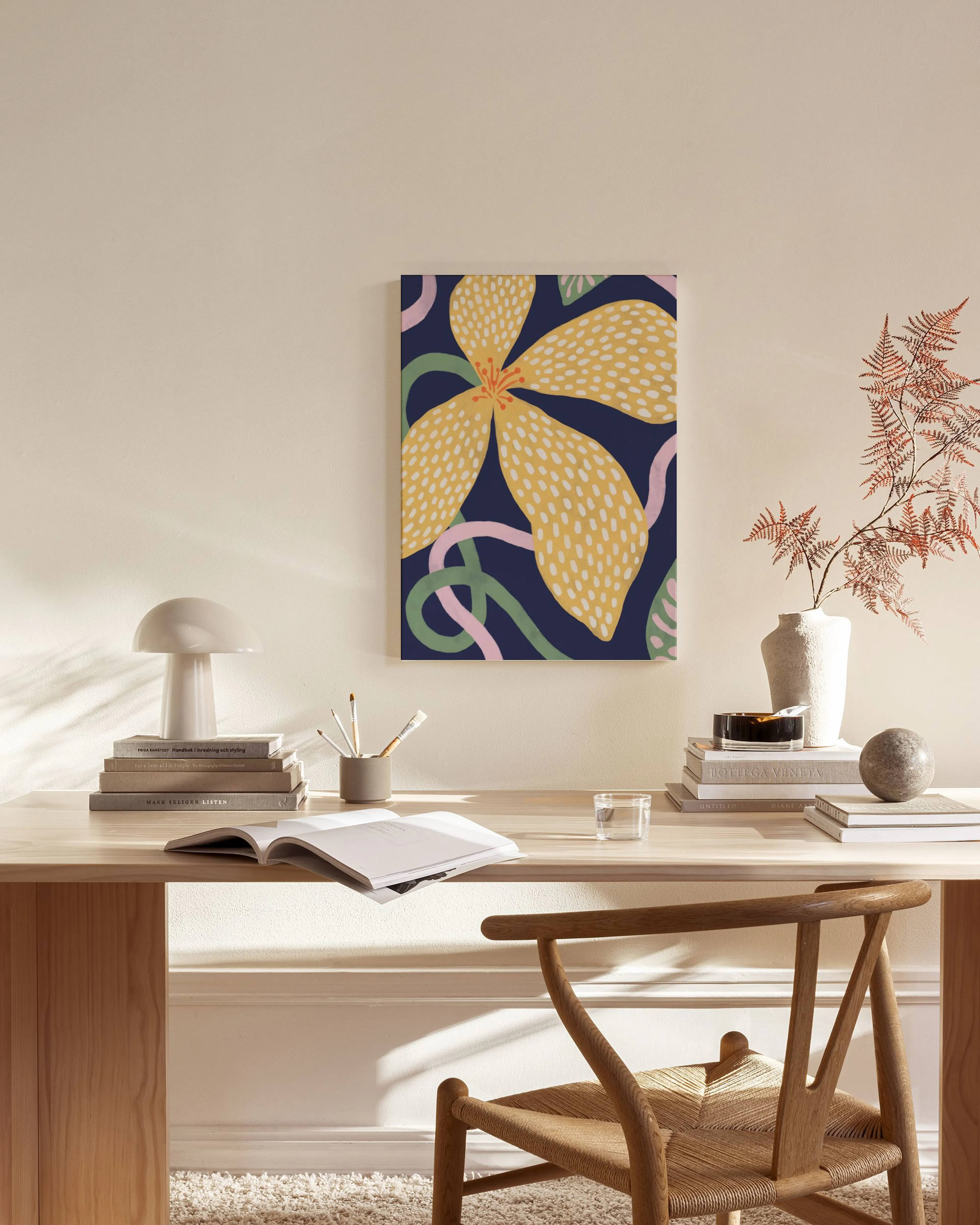 Abstraktes Leinwandbild mit gelber Blume und organischen Formen auf dunkelblauem Hintergrund, in einem modernen Wohnzimmer.